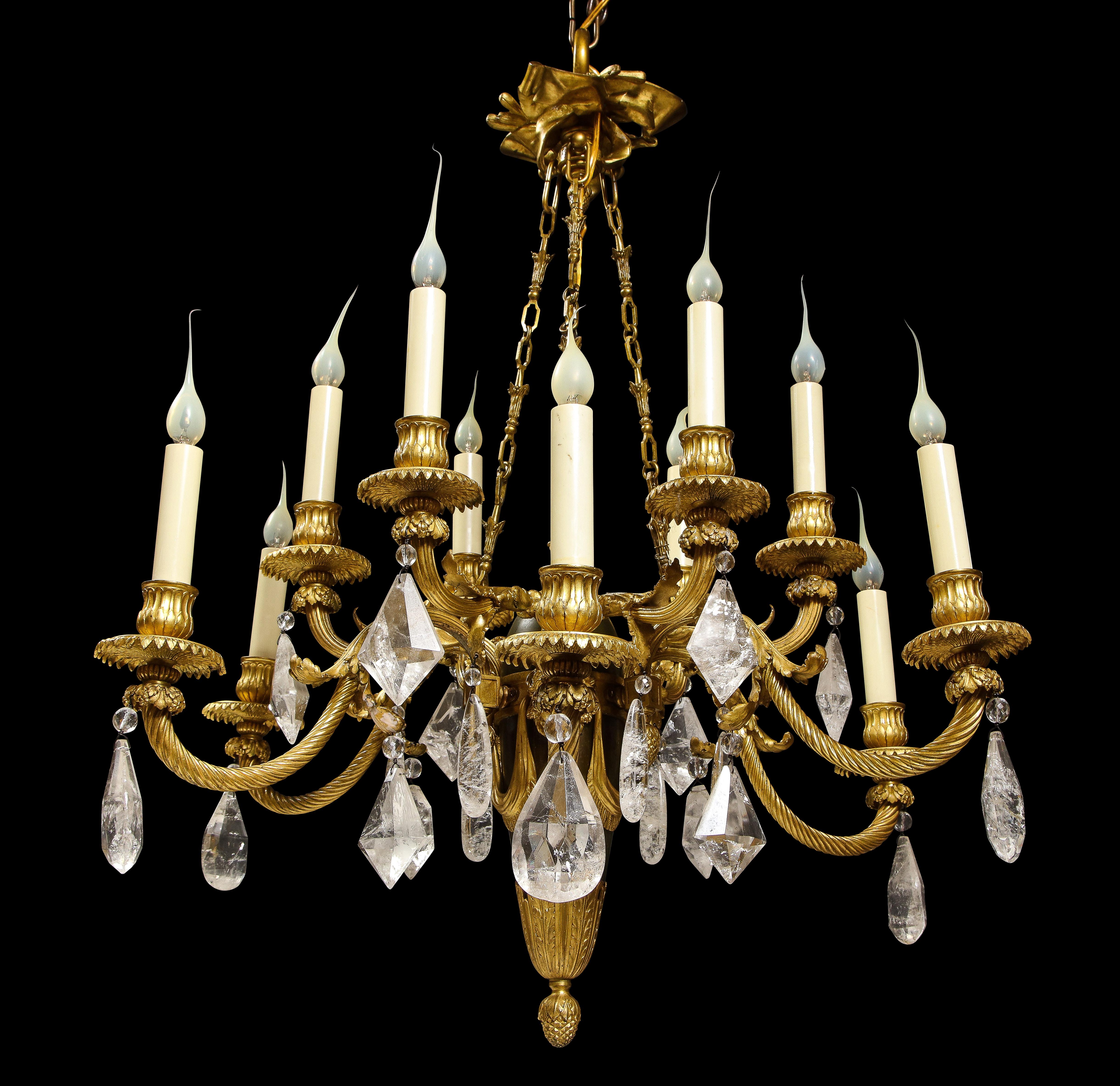 Ce lustre de style Louis XVI du XIXe siècle, en bronze doré et patiné, présente un design à double étage avec des bras élégamment torsadés. La partie supérieure est suspendue à un ruban décoratif, complété par des guirlandes florales drapées entre