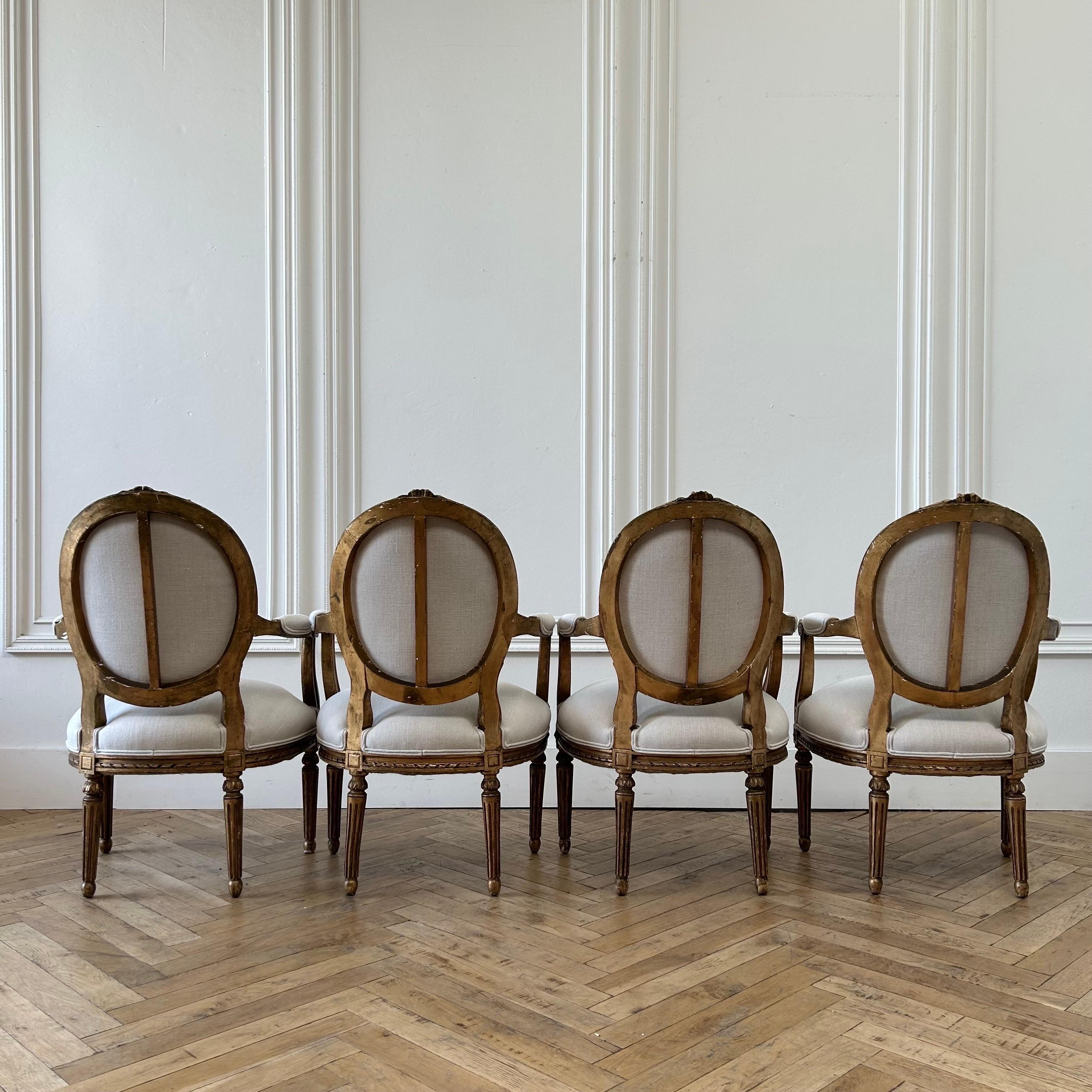 20th Century Antique French Louis XVI Style Gilt Wood Upholstered Linen Arm Chairs For Sale