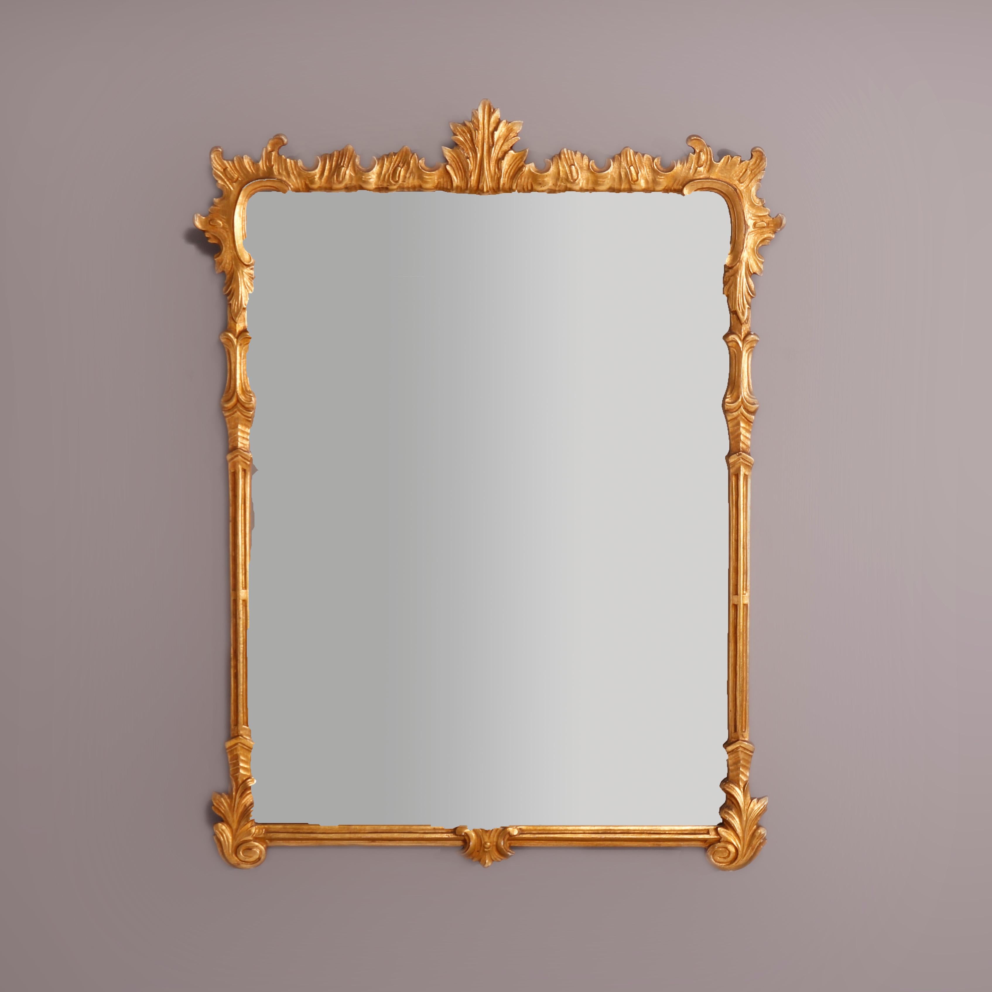 An antique French Louis XVI style wall mirror offers giltwood frame with foliate finial and elements throughout, maker label en verso as photographed, c1930

Measures - 40.75''H X 30.75''W X 1.5''D (overall) and 33.5