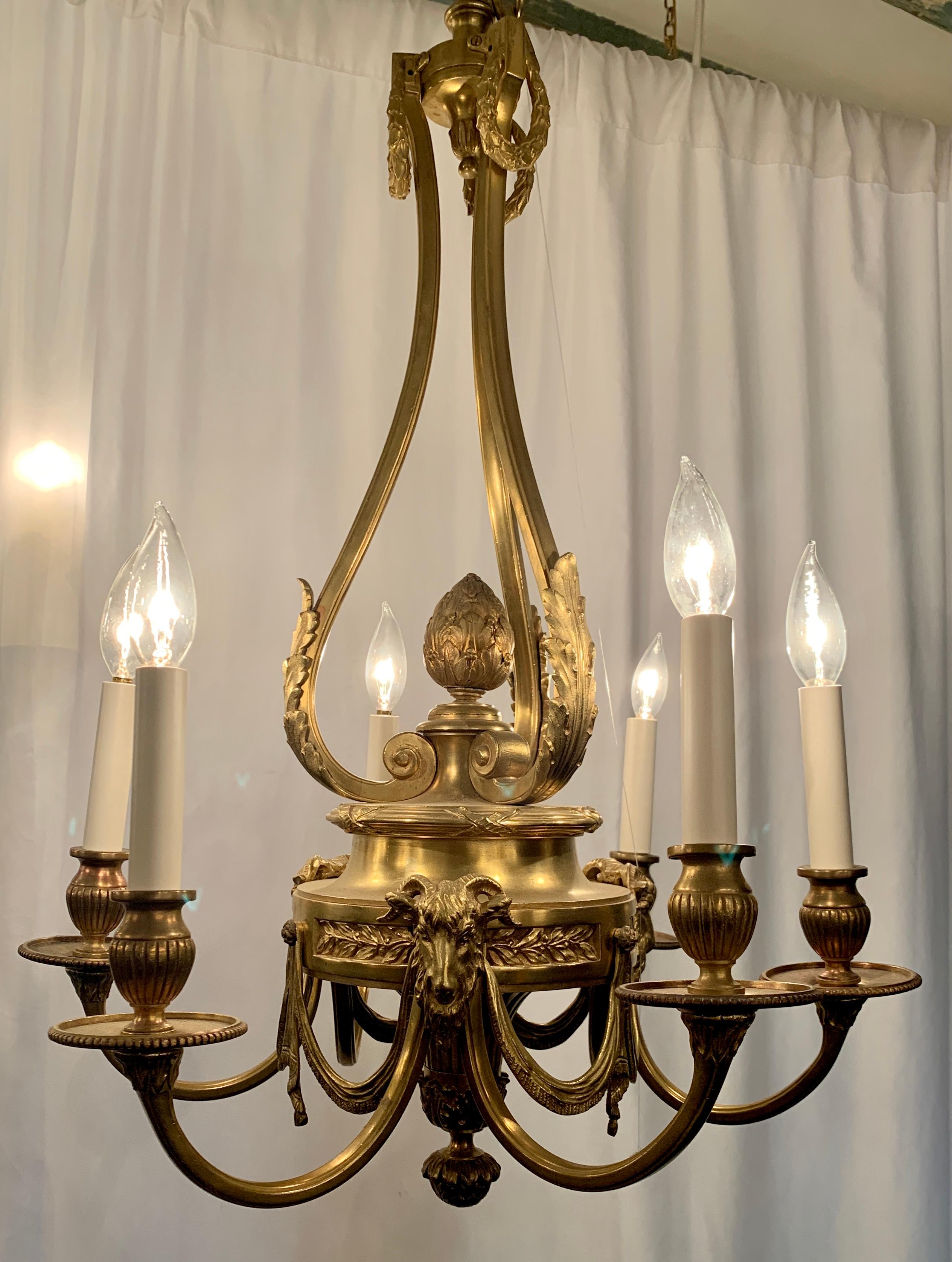 Antique French gold bronze Louis XVI style chandelier mounted with figural ram's heads, Circa 1870's.