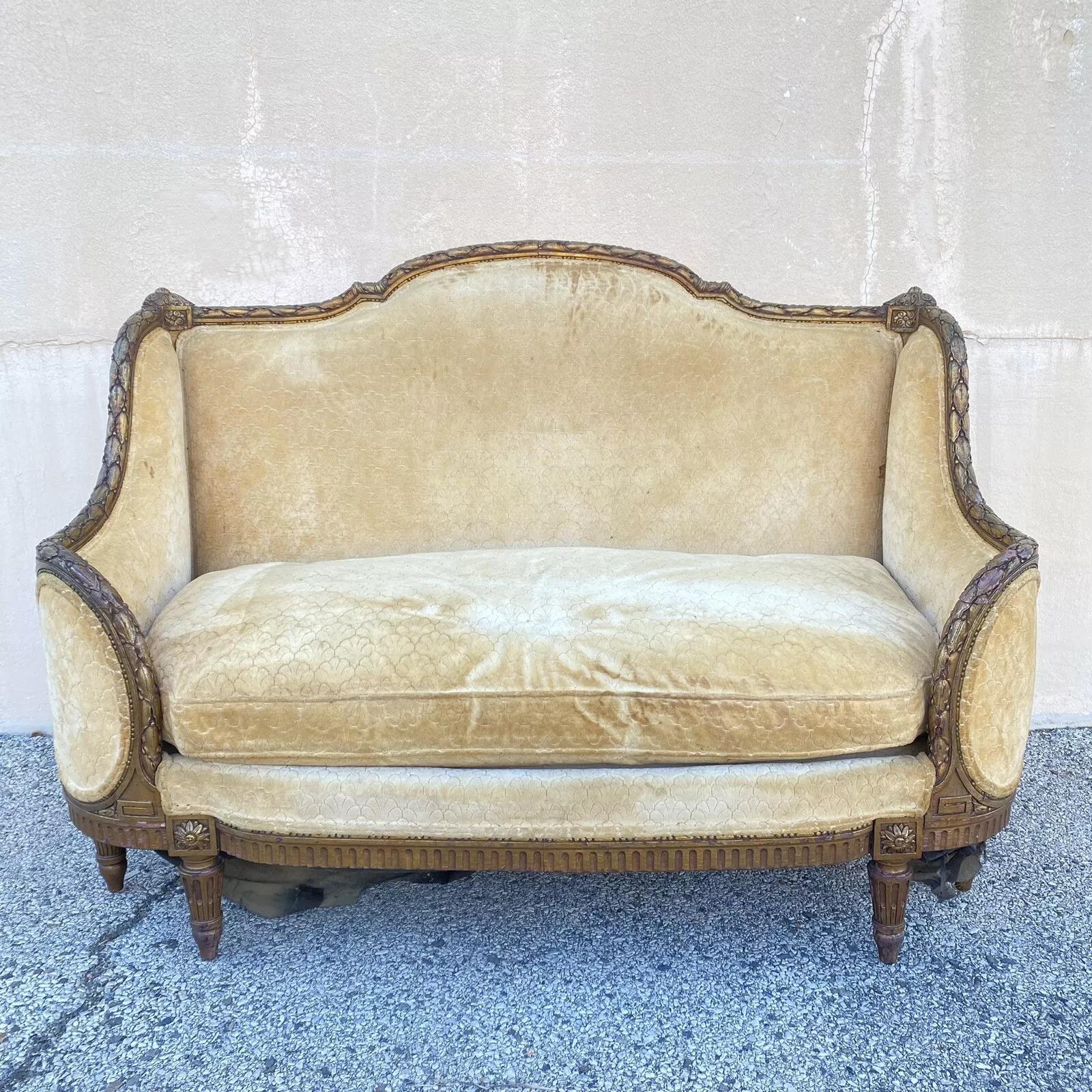 Canapé Canape Cameo en bois doré sculpté de style Louis XVI. L'objet présente un cadre curviligne très unique avec des panneaux 