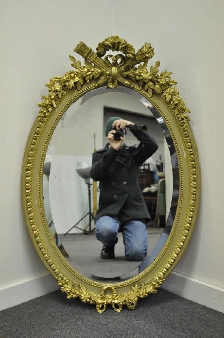 Antique French Louis XVI Style Gold Gilt Torch & Flame Crest Gesso Oval Wall Mirror. Circa Late 19th Century. Measurements: 41