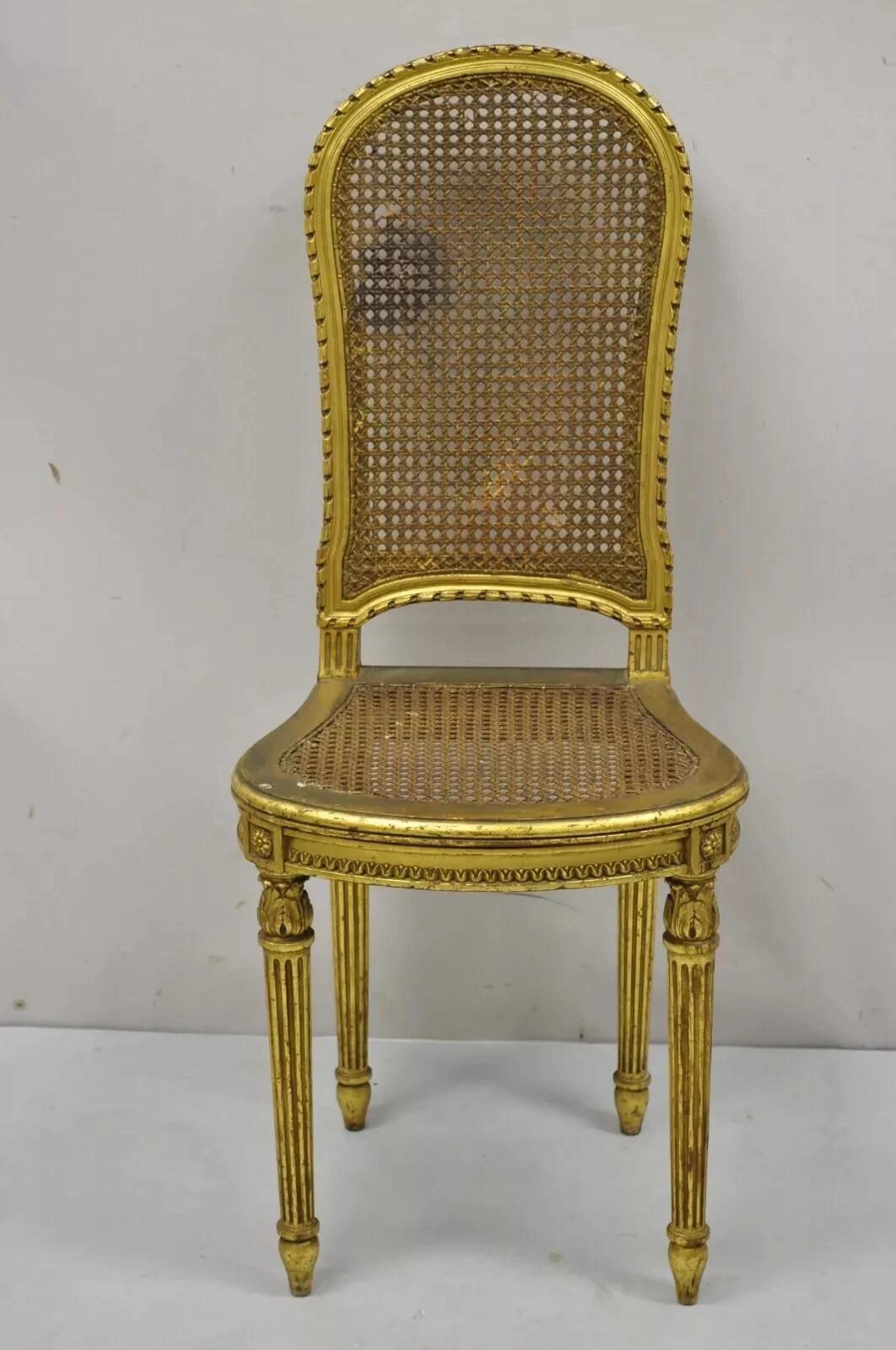 Antique French Louis XVI Style Gold Giltwood Cane Boudoir Vanity Side Chair. Item features a gold gilt finish, cane back and seat, solid wood frame, distressed finish, nicely carved details, tapered legs, very nice antique item. Circa Early 20th