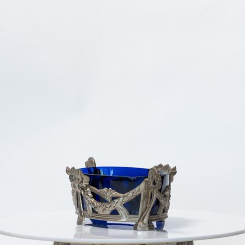 Here is a lovely Antique French Louis XVI style jardiniere with blue glass insert.

The cobalt blue glass insert of this antique jardinière or planter from the Louis XVI era immediately catches your eye. A sturdy frame detailed with garlands holds