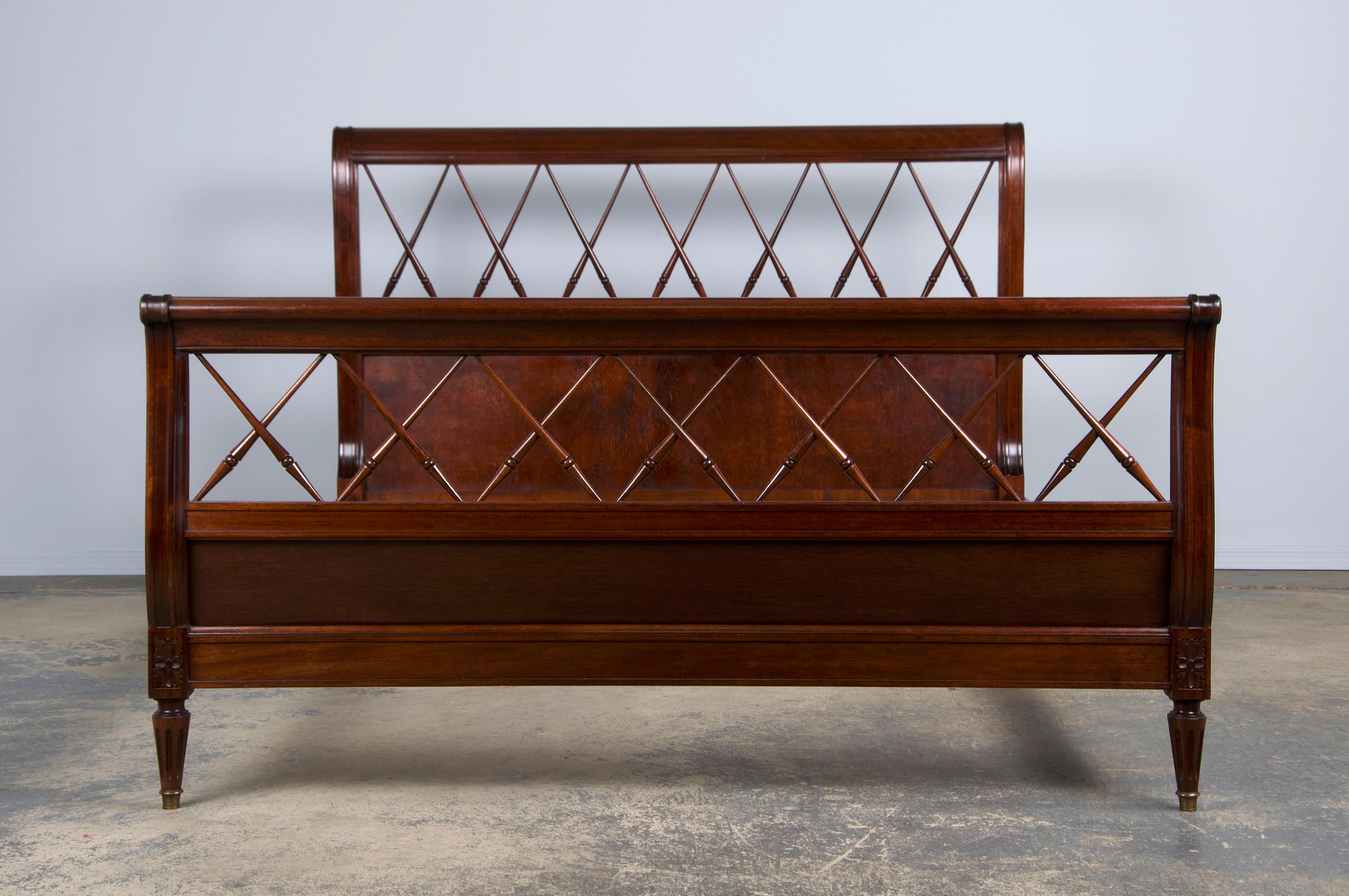 An exquisite early 20th-century French full-size bed frame in the Louis XVI style, sourced directly from Provence, France. Handcrafted from solid mahogany, this piece embodies European proportions and includes a headboard, footboard, and two