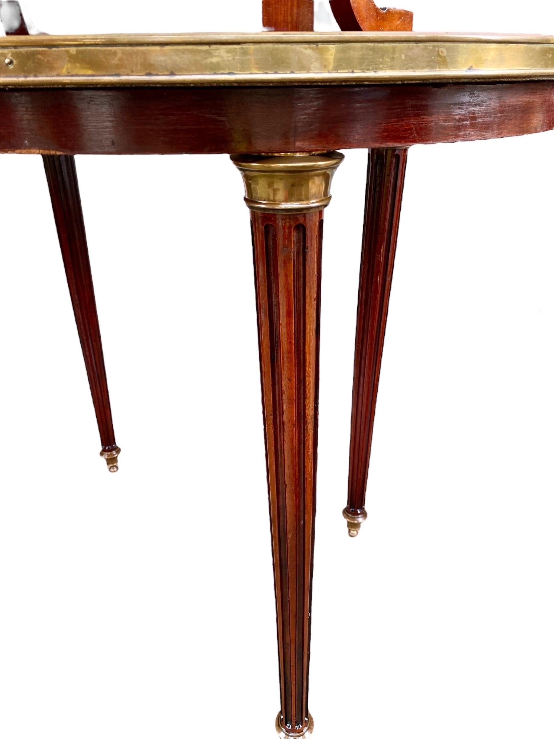 French Louis XVI style ormolu mounted carved mahogany marble top desserte early 20th century, the brass galleried, oval Breche d’alps tan marble top on four reeded cabriole supports to a lower oval brass bound mahogany shelf with handles on turned