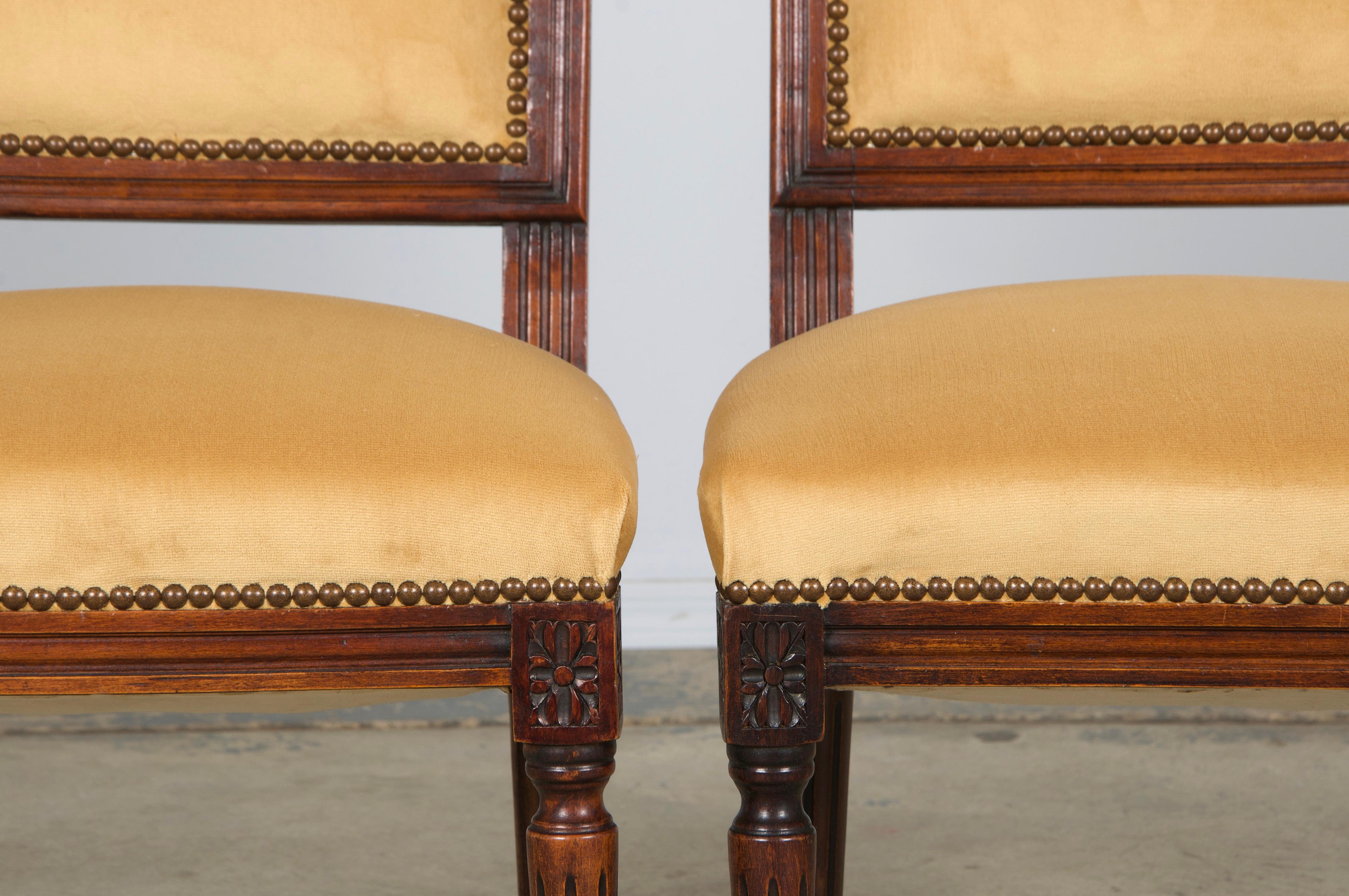 An exquisite pair of early 20th-century accent side chairs in the Louis XVI style, sourced from Provence, France. Each chair features a hand-crafted maple frame with a square back and a naturally aged dark patina. Structurally restored for lasting