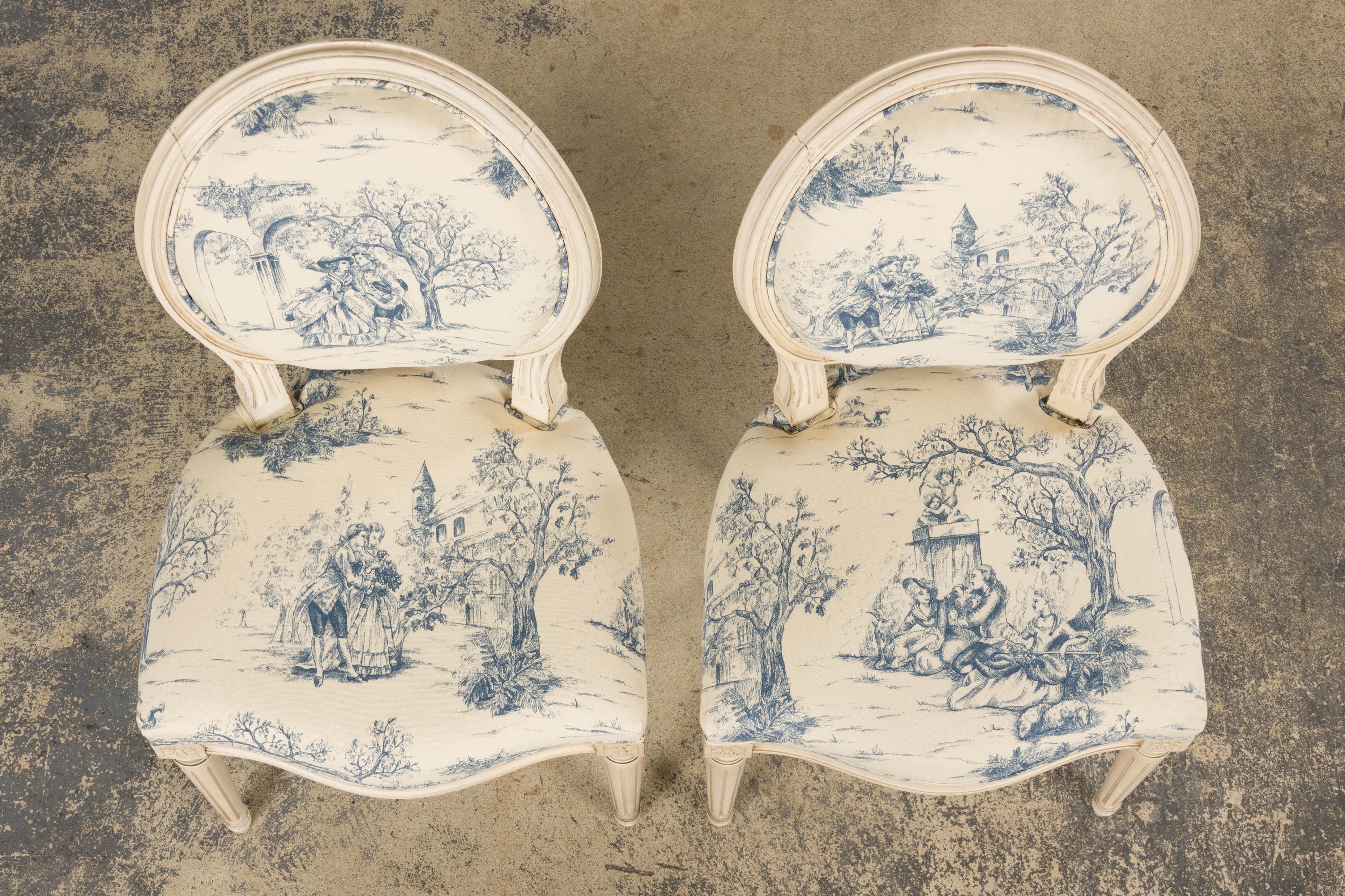 Une exquise paire de chaises d'appoint françaises anciennes de style Louis XVI, provenant de Provence, France. Chaque pièce est dotée d'un dossier ovale finement sculpté à la main, fini en peinture blanc antique crémeuse avec une patine