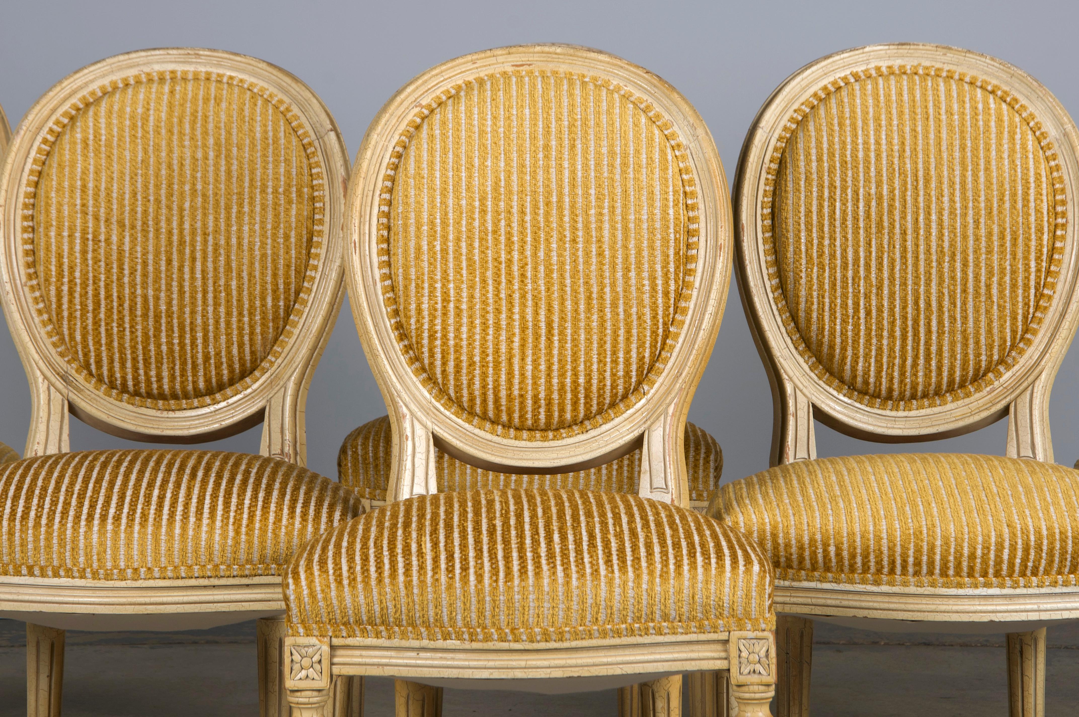 Un ensemble exquis de six chaises de salle à manger françaises anciennes de style Louis XVI, provenant de Provence, France. Chaque chaise est dotée d'un cadre moulé à la main et d'un dossier en médaillon de forme ovale. La finition en laque blanc