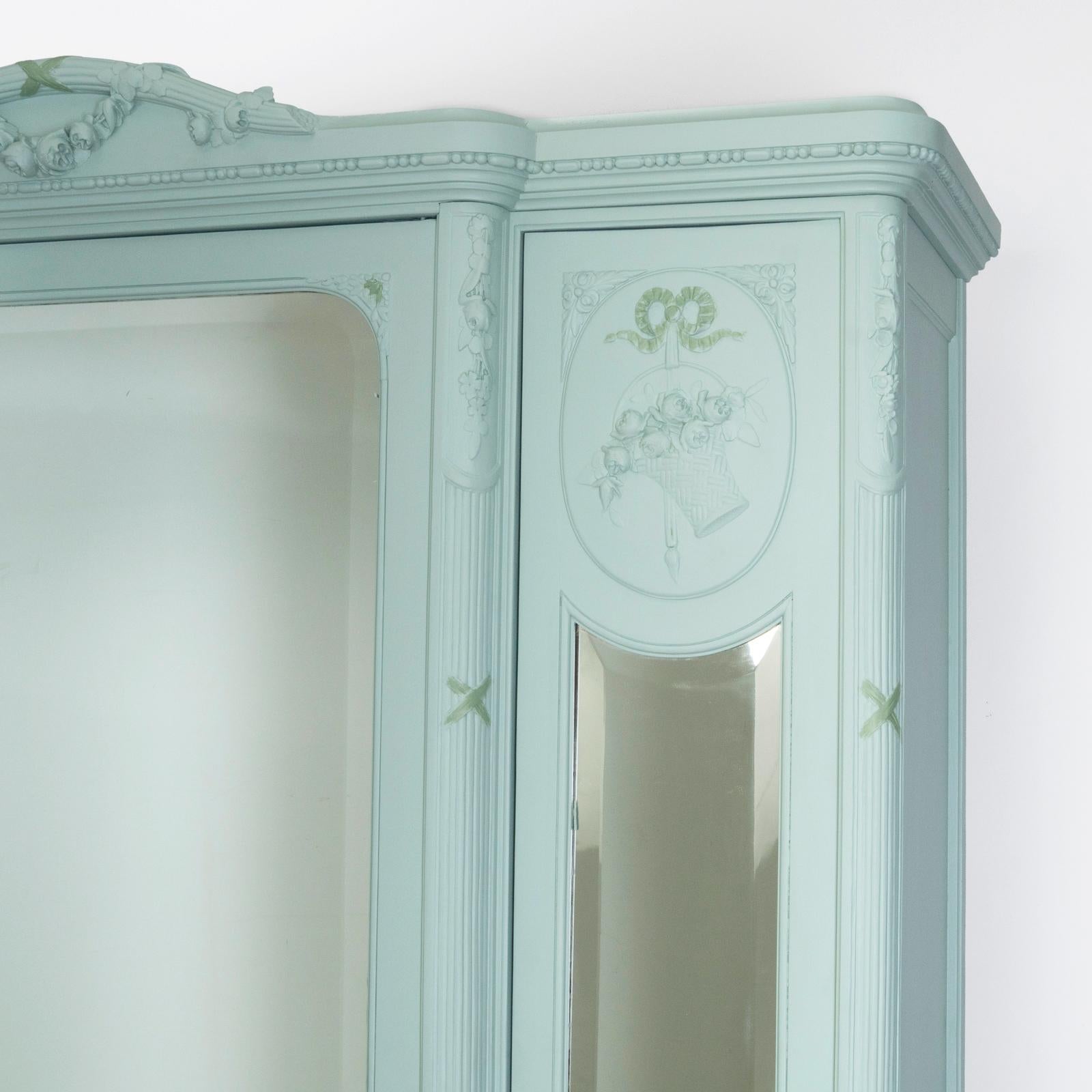 Exquisite 19th Century Louis XVI Style Triple Door Mirror Armoire – a perfect blend of elegance, design, and practicality!

Adorned with decorative oval panels, the side mirror doors exhibit an exceptional touch. The full-length beveled mirrors not