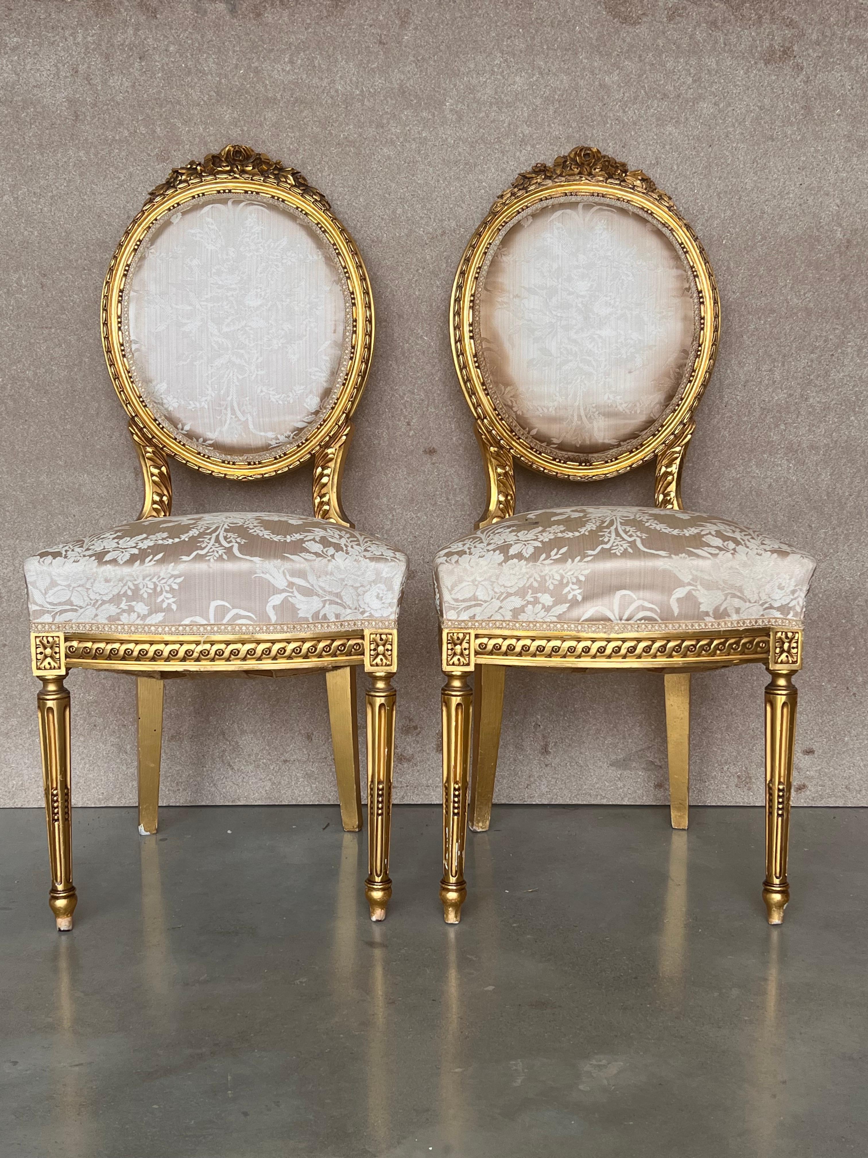 French Louis XVI style dining side chair from Paris decorated with timeless classical styling and hand carved excellence on the entire framework, emphasizing typical neoclassical gilt carvings of acanthus leaves and laurel wreaths, circa 1920s.