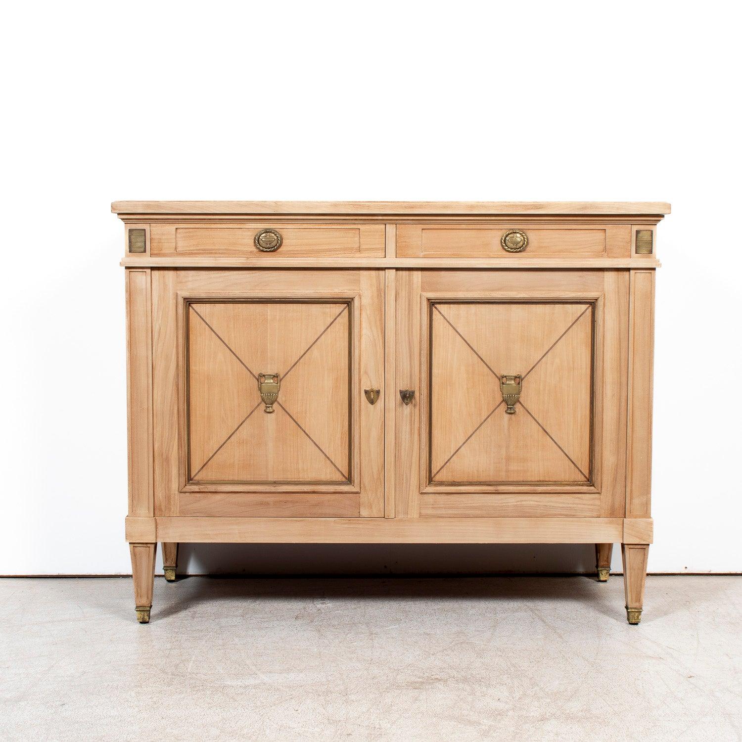 Elegant yet quietly commanding, this early 20th century French Louis XVI style buffet, circa 1900, blends classical symmetry with a soft, sun-bleached finish that highlights its refined neoclassical details. Handcrafted in the South of France from