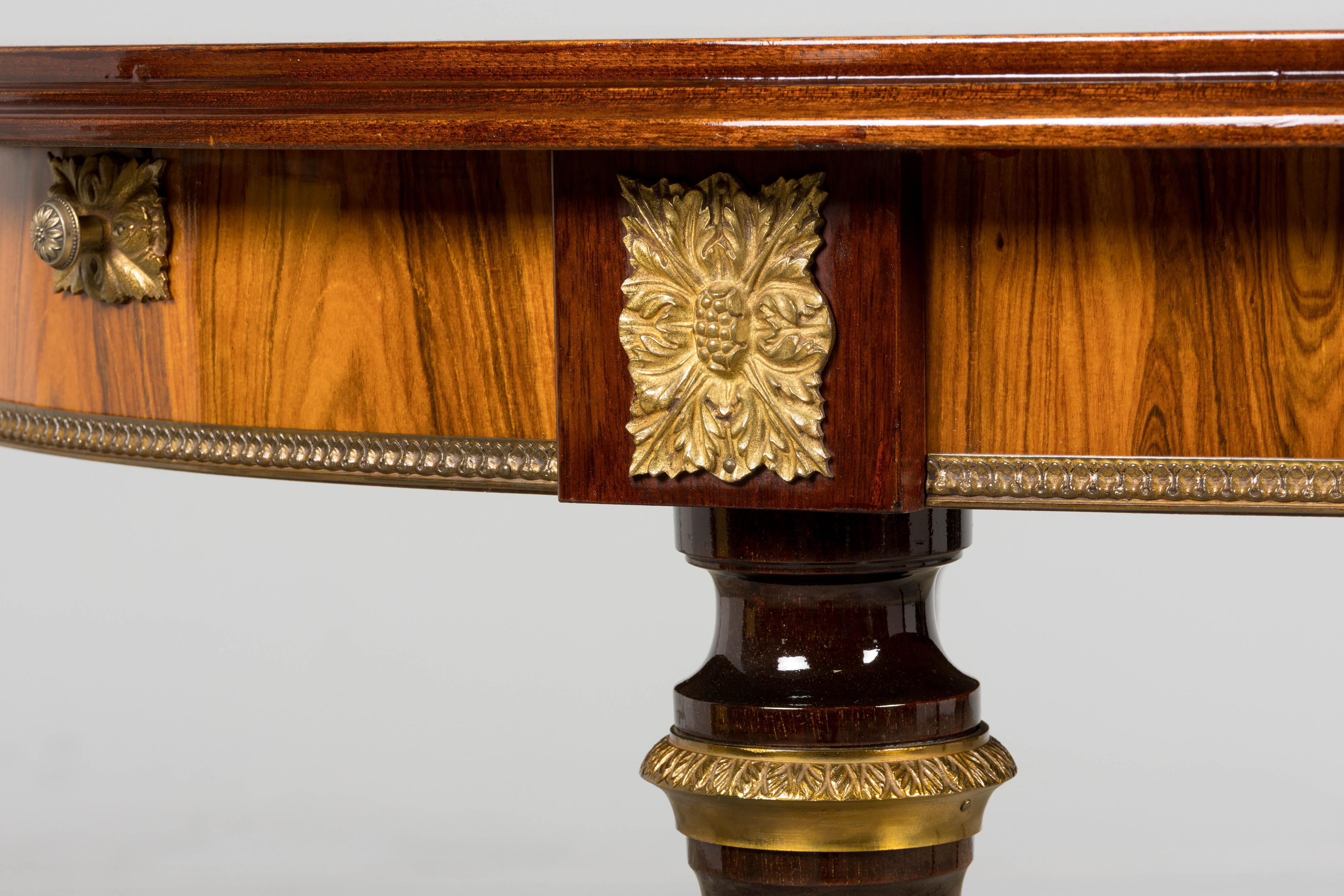 A refined late-19th-century French Louis XVI style dining table sourced in Provence. The oval top is beautifully crafted with chevron-laid rosewood veneer and a central floral marquetry medallion composed of multiple fruitwood and hardwood species.