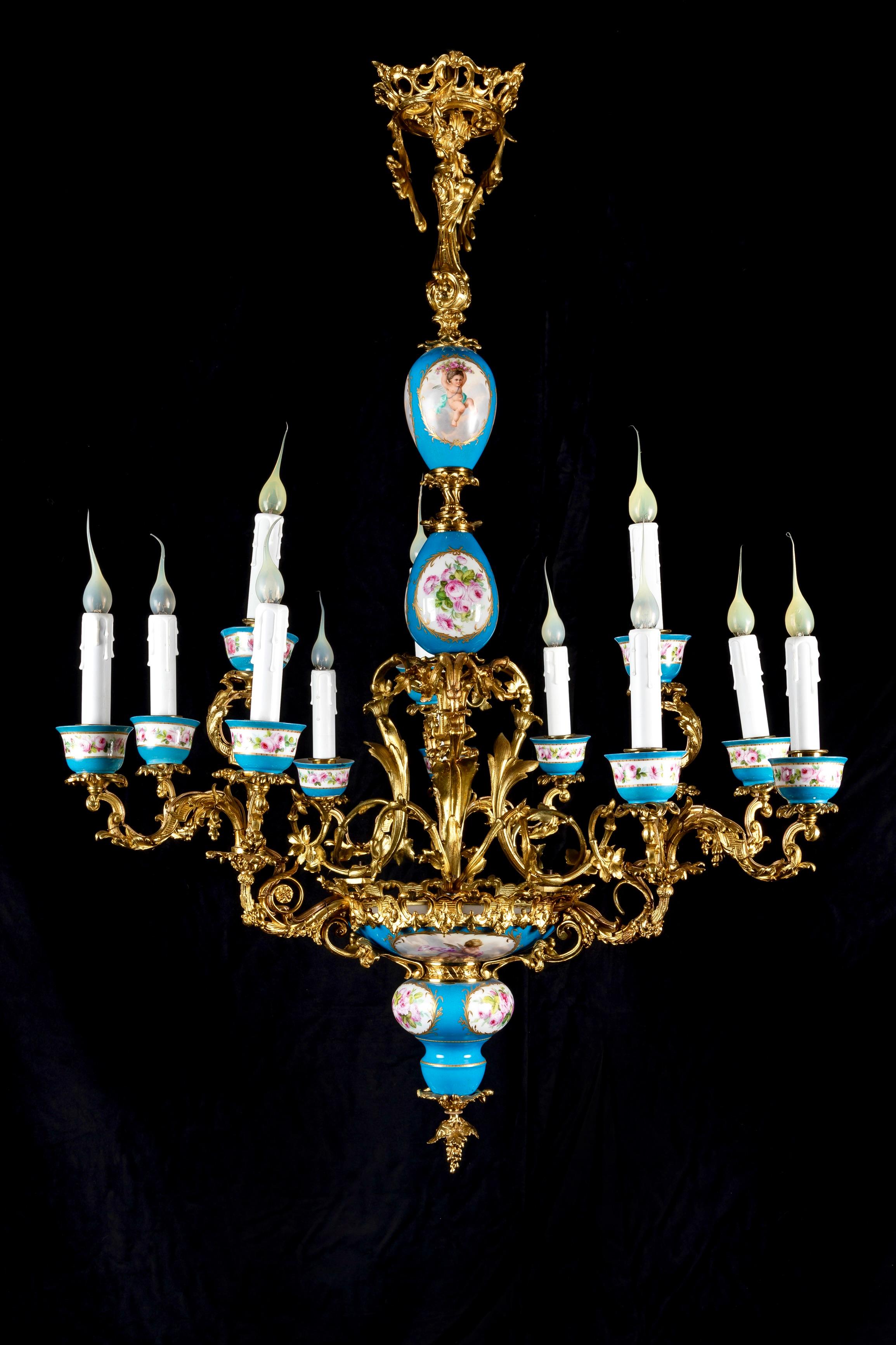 A Spectacular large 19th century blue Sevres porcelain and gilt bronze multi arm double tier chandelier of exquisite craftsmanship. The main body of this unique blue Sevres porcelain chandelier displays 12 oval form panels of polychromed hand