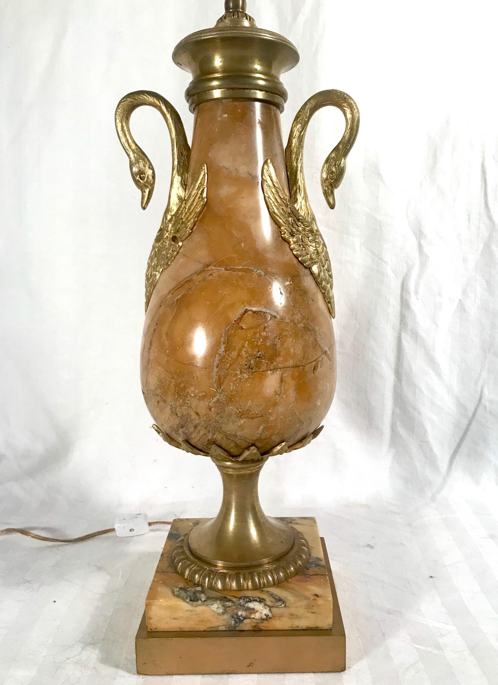 Antique French Louis XVI style sienna marble and ormolu urn

Elegant 19th century sienna marble and ormolu urn converted as a table lamp. The baluster shaped urn is decorated with graceful swan ormolu handles. The urn lamp is supported on a bronze
