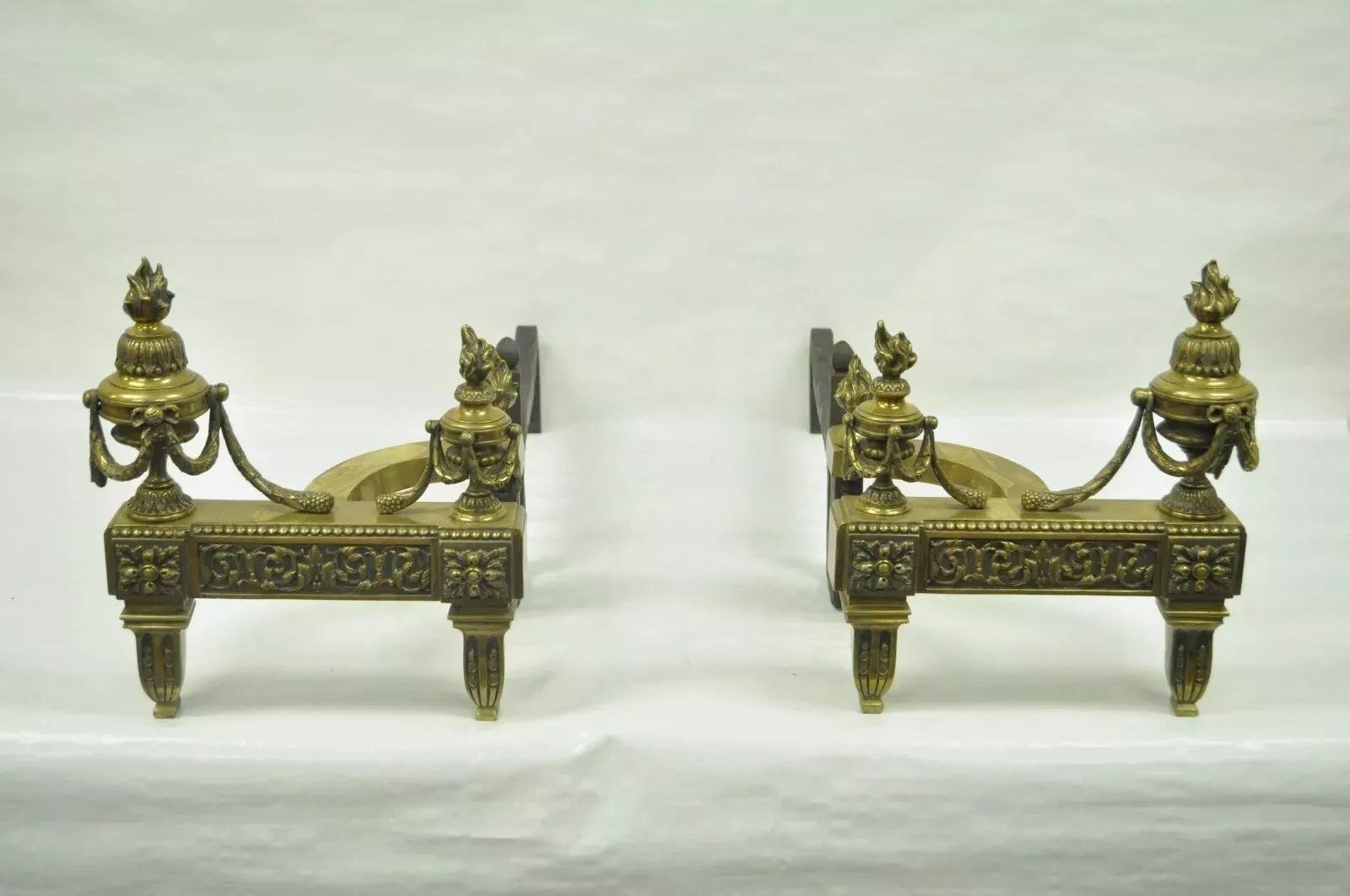 Antike Französisch Louis XVI Stil Urne Flamme Messing Bronze Ormolu Andirons - ein Paar. Der Artikel hat eine Urnenquaste und eine Flammenform, gusseiserne Feuerhaken, klassisches französisches Design. CIRCA Anfang des 20. Jahrhunderts. Abmessungen: