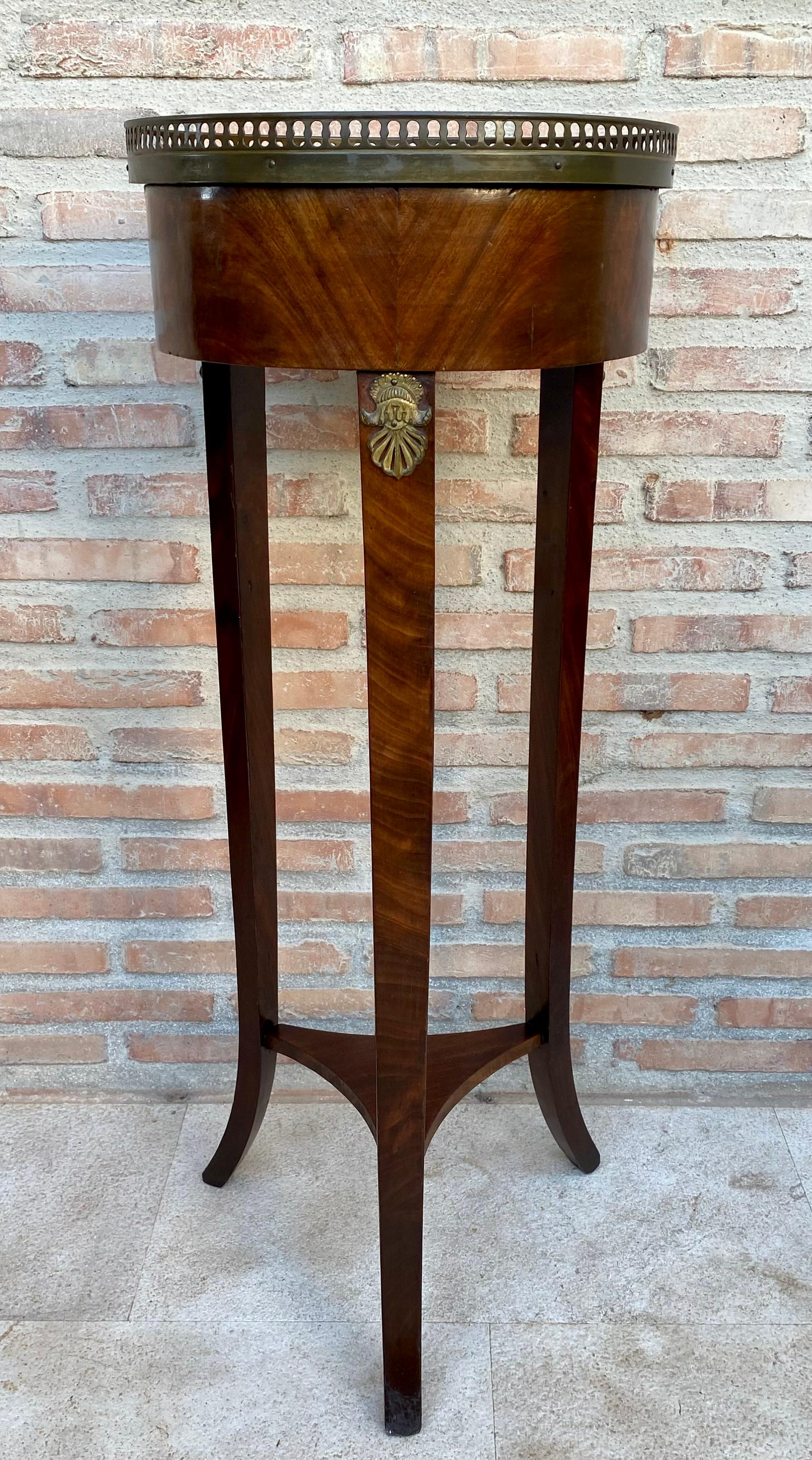 Table Bouillotte en noyer de style Louis XVI du 19ème siècle.
Ancienne table Bouillotte en noyer de style Louis XVI avec plateau à galerie en bronze, un seul tiroir et une petite étagère ornée de marqueterie. Notre table Bouillotte est la table