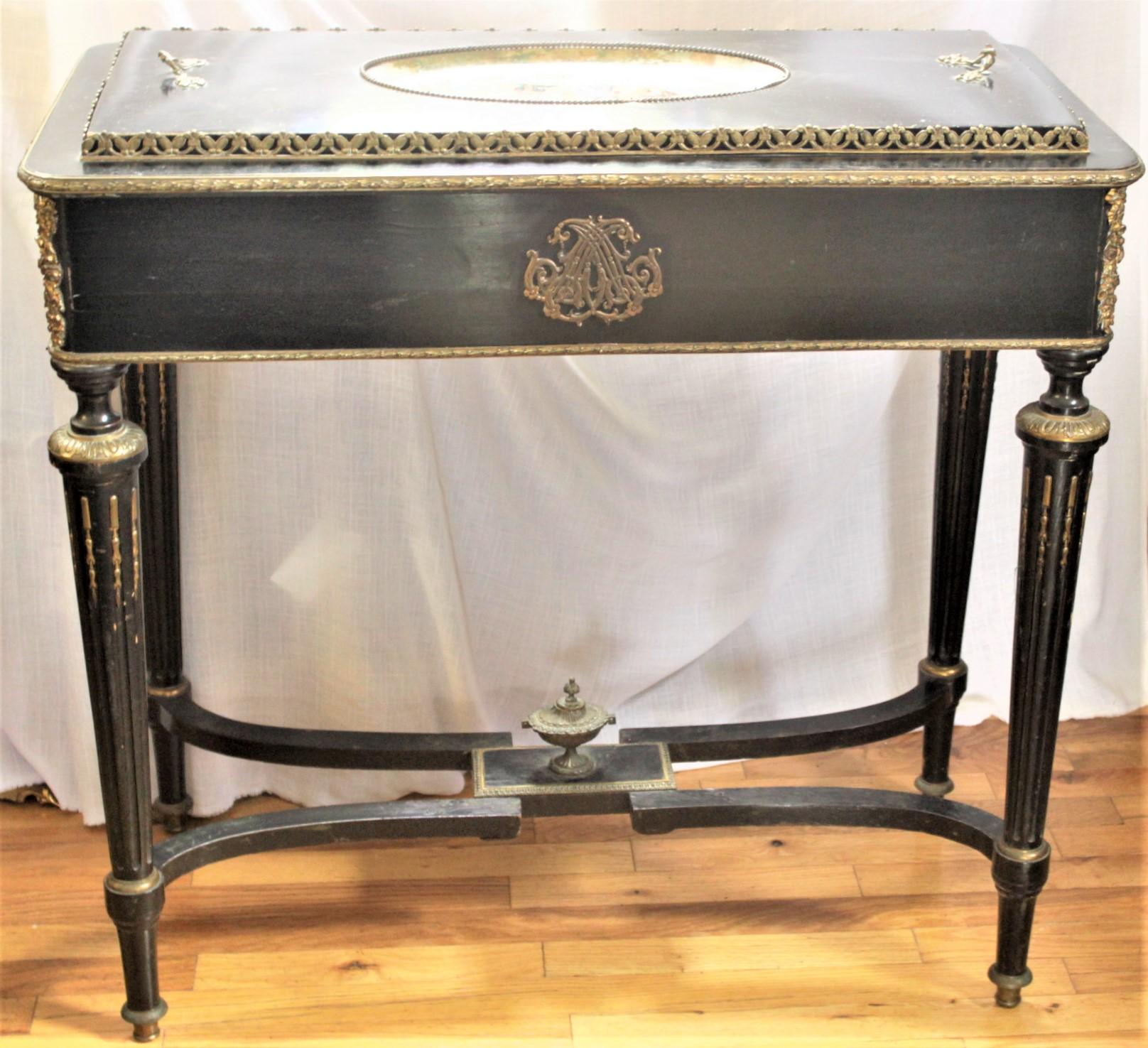 This antique jardinière table is unmarked, but presumed to have been made in England or France is circa 1890 in a Louis XVI style. The table is composed of wood which has been painted black with gold accents. The fitted top features a large oval