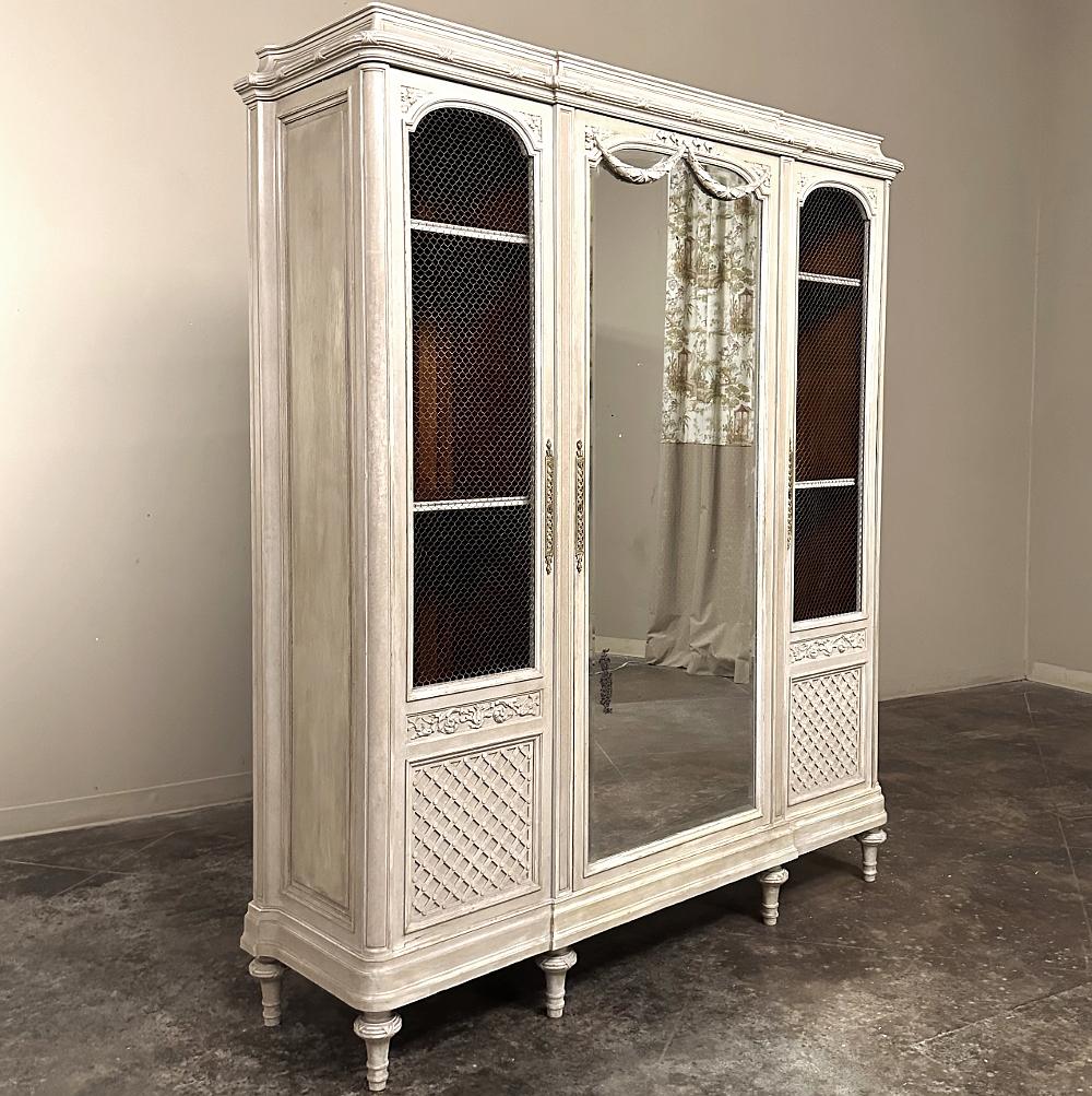 Antique French Louis XVI Triple Painted Armoire ~ DIsplay Armoire is a magnificent ode to the neoclassical style, rendered in fine hardwoods and mahogany then finished in a neutral paint that has achieved a lovely patina over the decades.  Starting