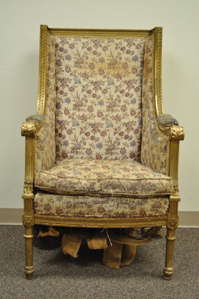 Stunning antique French Victorian giltwood wingback armchair. The chair features carved and applied acanthus and geometric accents, a large and impressive profile, and an original distressed gilt finish. If the piece is to be used for seating the