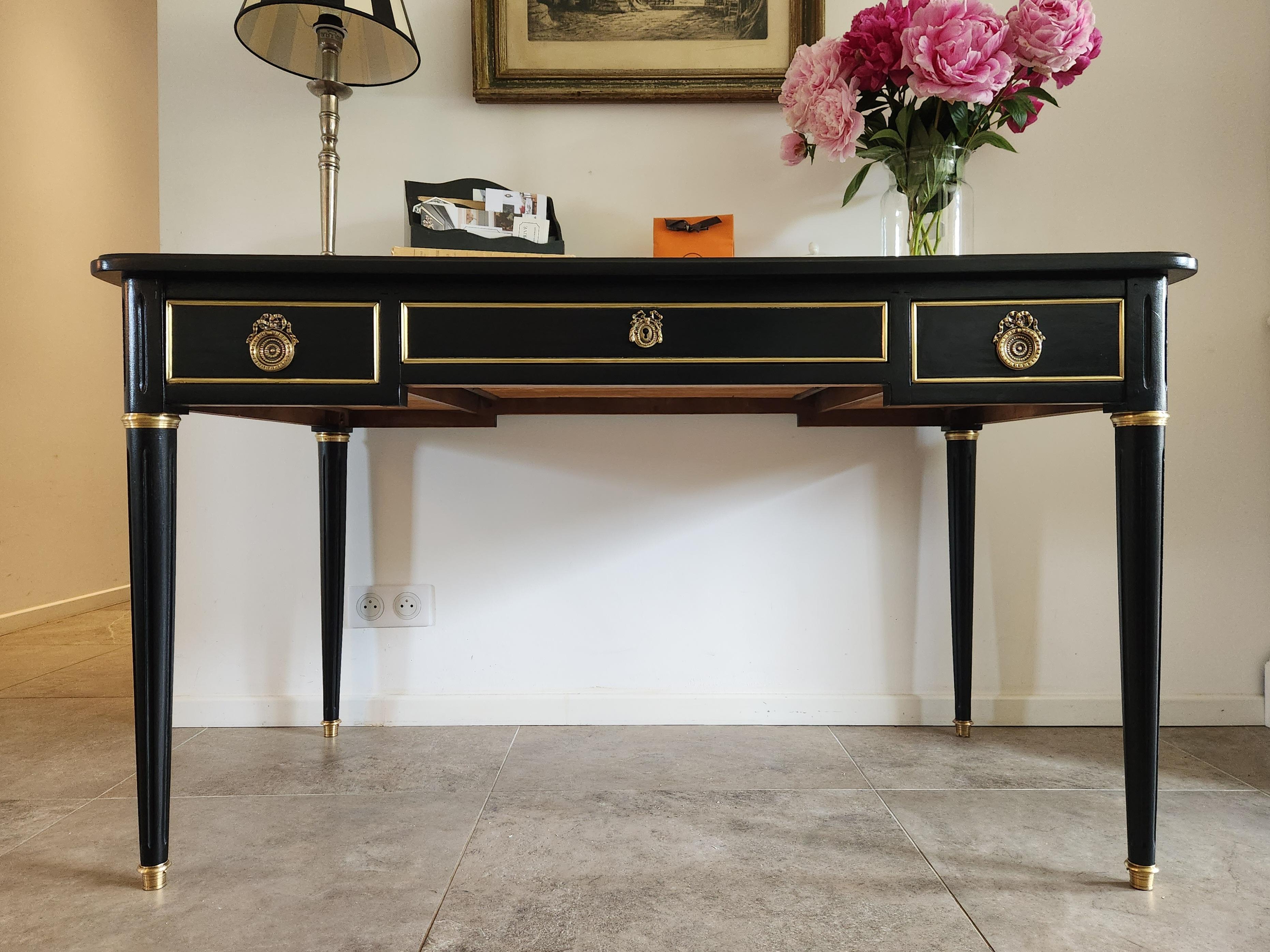 Antique Louis XVI style desk with cognac leather top.
The front of the piece has three dovetail drawers with brass details.
The back of the piece is drawn like the front, with false decorative drawers, so this desk is also perfect be placed in the