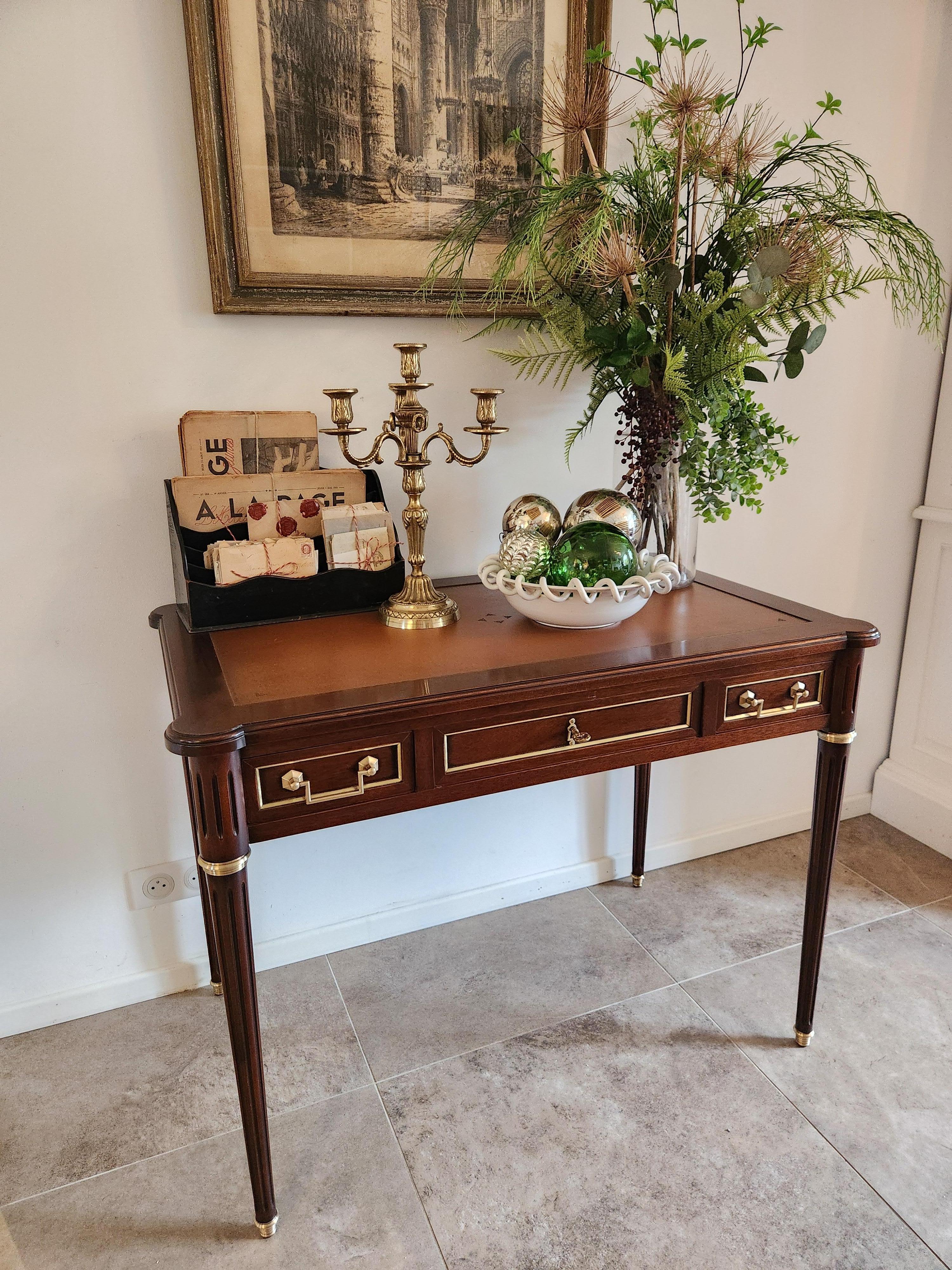 Antica scrivania in stile Luigi XVI con piano in pelle cognac.
La parte anteriore del pezzo presenta tre cassetti a coda di rondine con dettagli in ottone.
Anche gli altri tre lati sono decorati con dettagli in ottone e ogni estremità è dotata di un