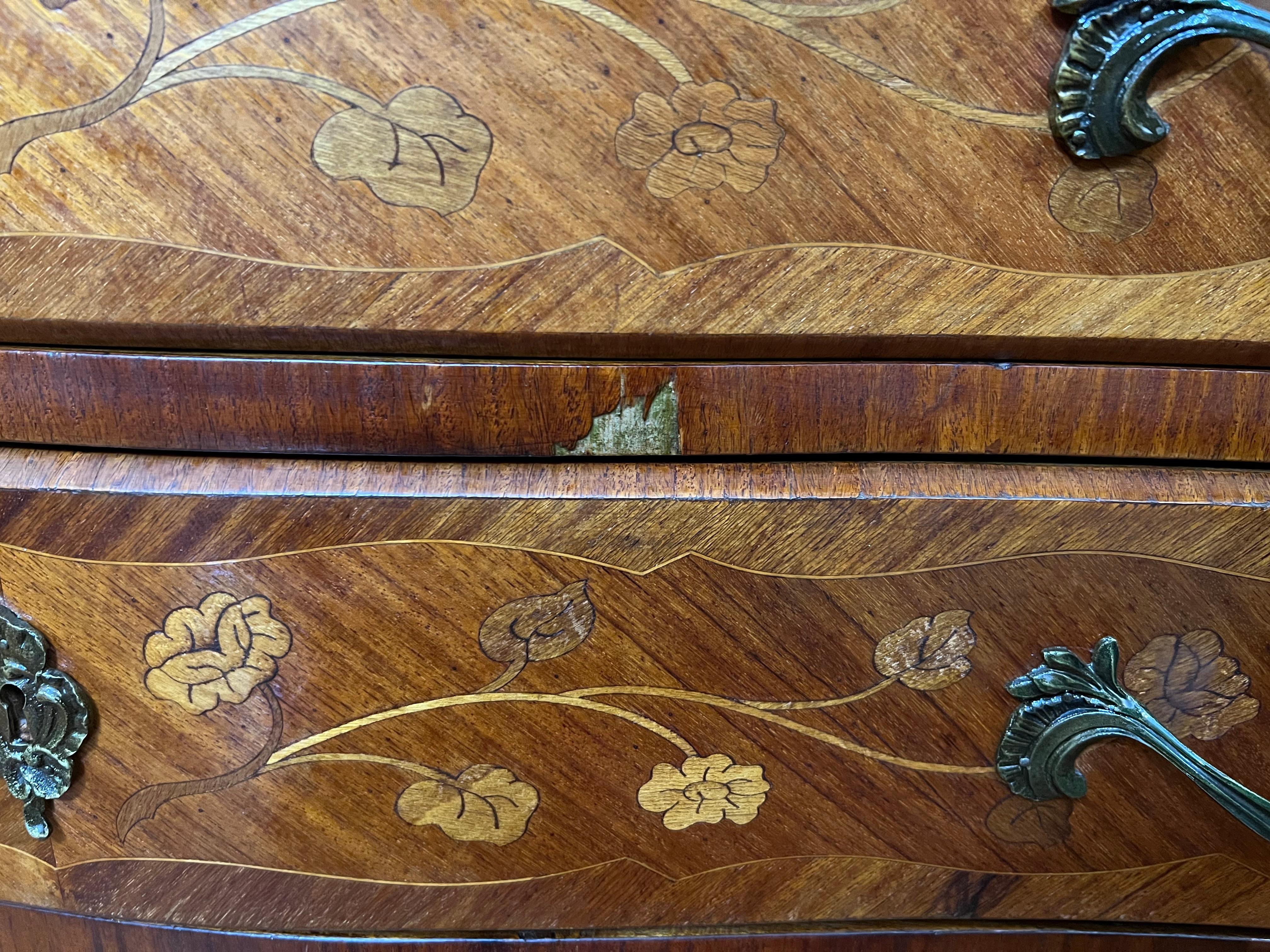 Walnut inlay design to both front and sides, three drawer space with beautiful detail brass handle pulls, brass detail to legs, curved marble top. There are some wear to the front of the item and one side on the drawers, please see photos.