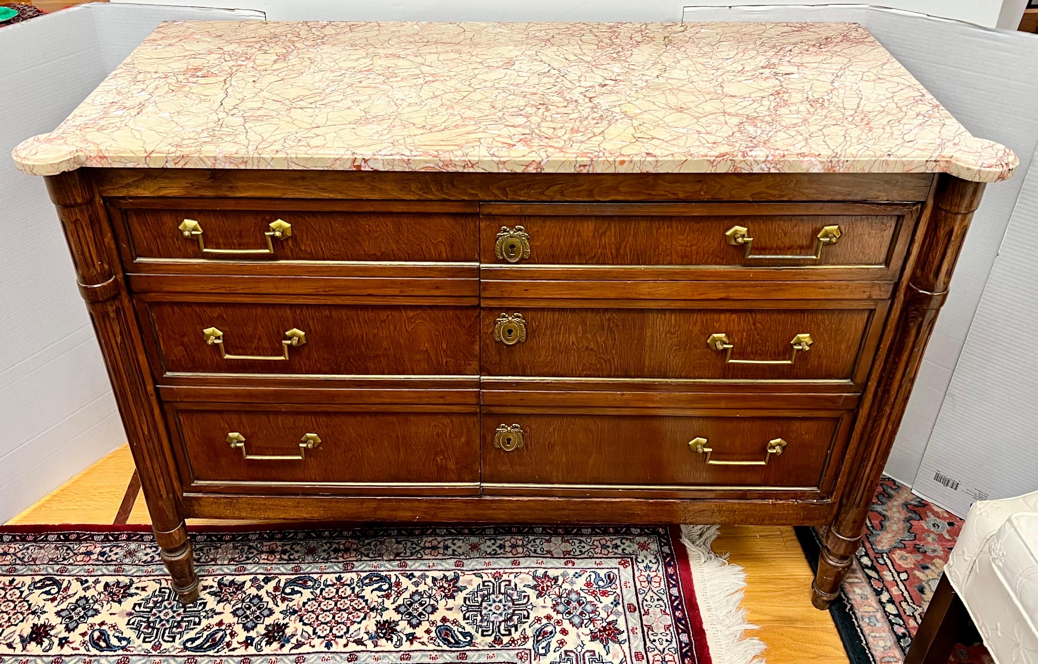 Exquisite French mahogany credenza features a pink marble top with beautiful veining. It has a faux six drawer front that are actually double doors that open to shelving. Beautiful original brass hardware.