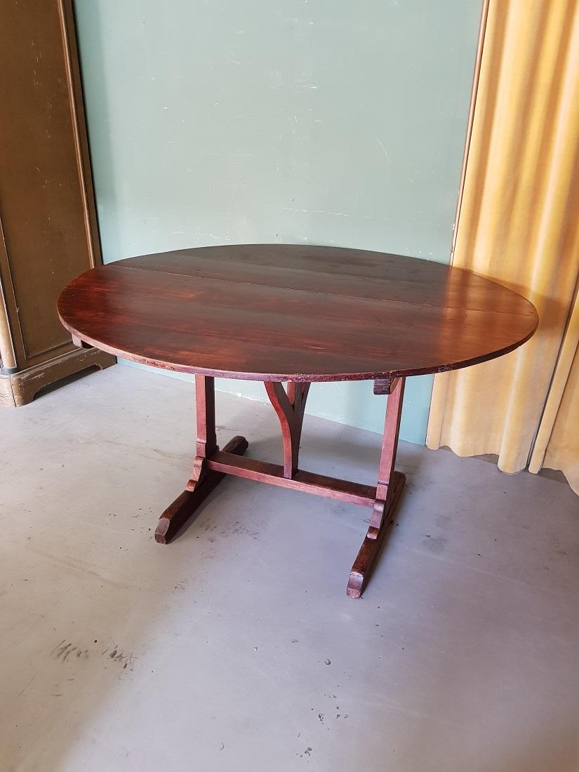 Large model antique French mahogany colored wooden wine table from the champagne region, whose leaves can be folded up and therefore easy to put away. This continues in a good but used condition and old restorations. Originating from the early 20th