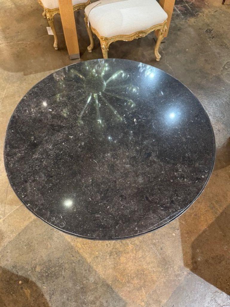 La table ancienne française en acier et laiton de style Maison Jansen avec marbre noir est un meuble luxueux et élégant qui respire la sophistication. Le plateau en marbre noir ajoute une touche de luxe, tandis que les éléments en laiton antique et