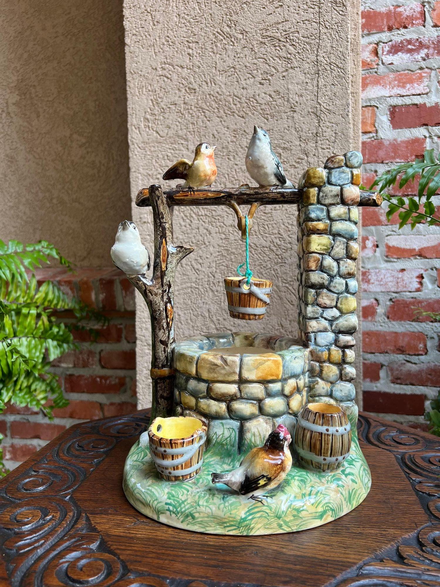 Antique French Majolica Bird Wishing Well Flower Holder Cache Pot Jerome Massier.

¡Directo de Francia, una pieza de mayólica francesa rara y única que presenta una multitud de pájaros alrededor de un pozo de los deseos empedrado!
Una gran rama de