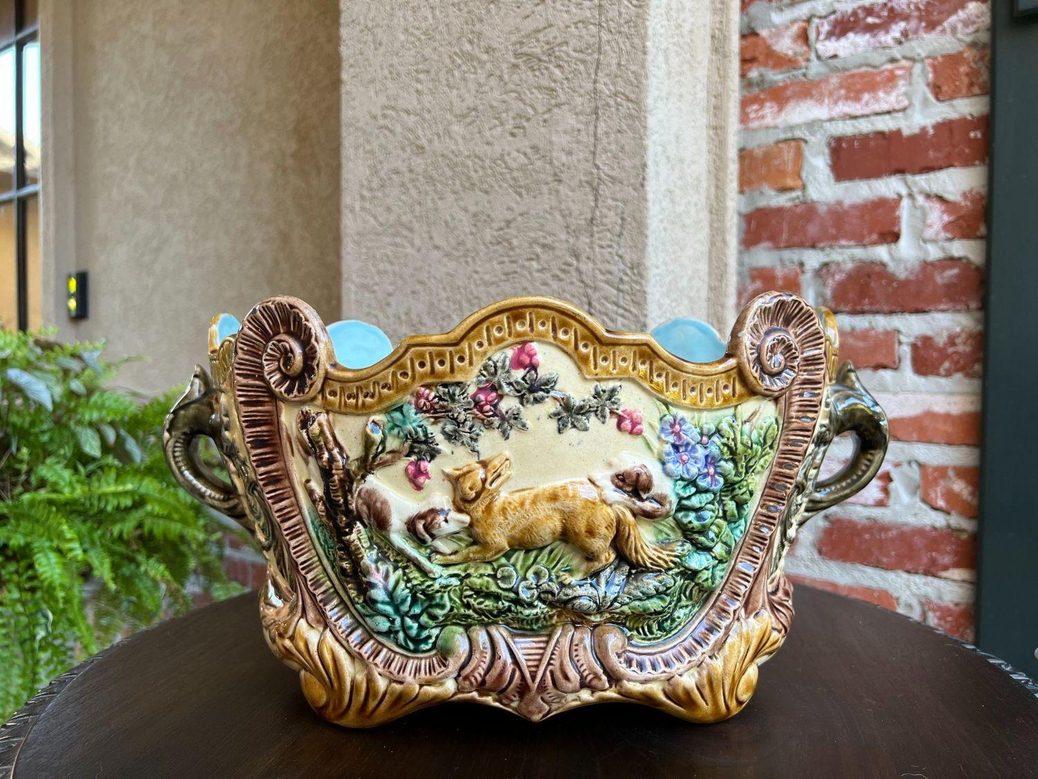 Antique French Majolica Cache Pot Jardinière Dog Fox Hunt Forest Scene Planter.

Direct from France, a gorgeous antique French majolica cache pot! This unique design features a fox ‘hunt scene’ with two dogs surrounding the fox.
Amazing details,