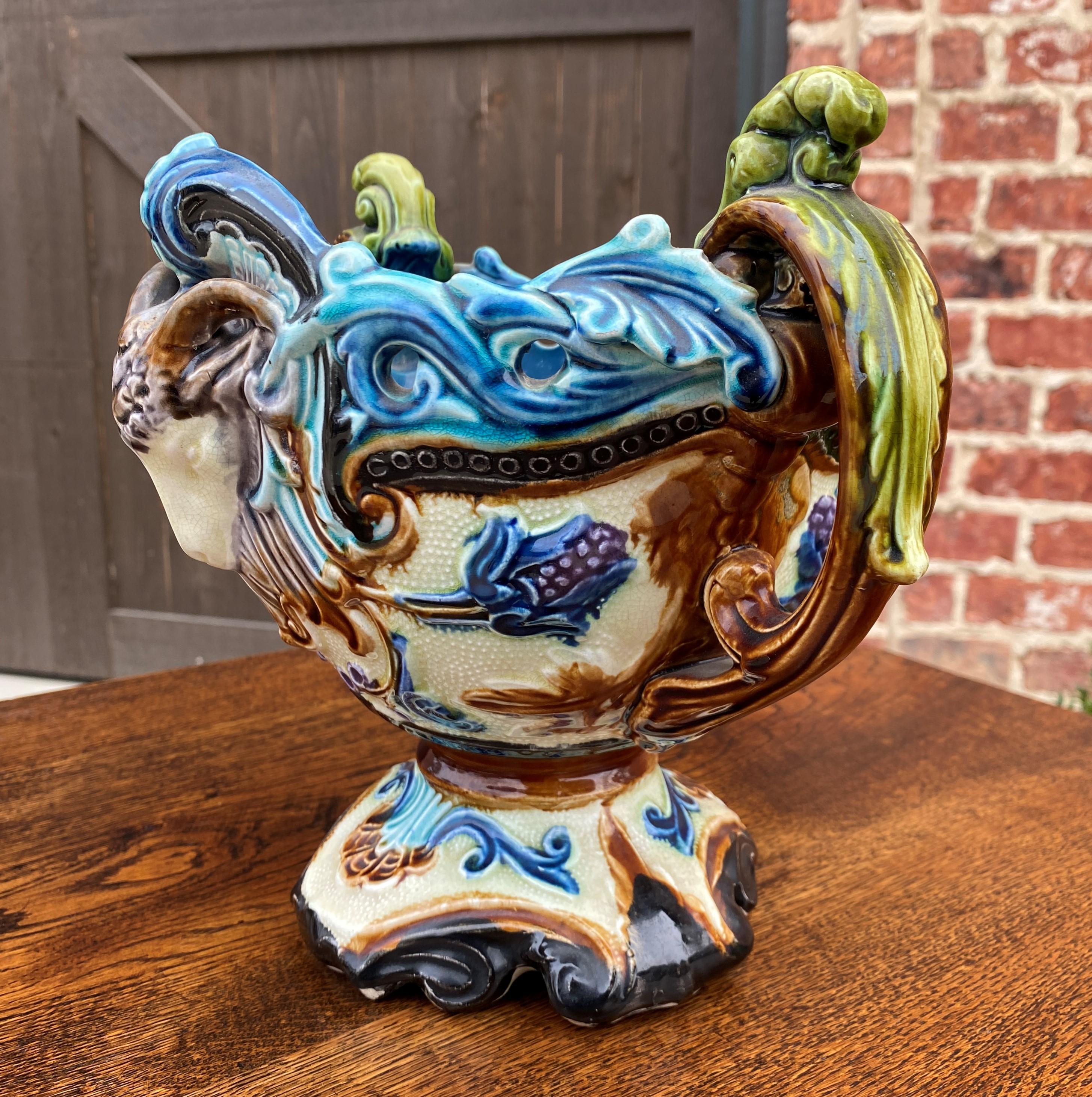 Gorgeous Antique French Majolica Footed Cache Pot, Planter, Jardiniere, Flower Pot or Vase~~c. 1900

Authentic French majolica planter or cache pot~~vibrant colors of teal, brown, gold, and green with ram heads on either side~~a must have for