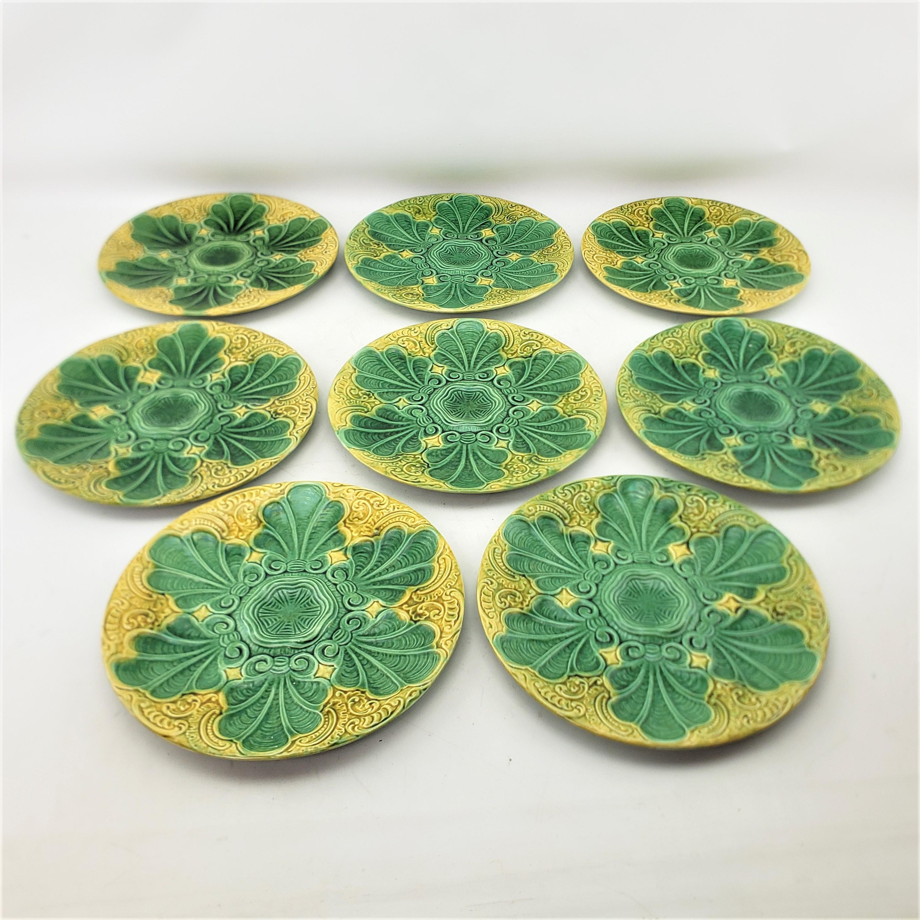This set of antique oyster or seafood plates are signed by an unknown maker, and presumed to have originated from France and date to approximately 1880 and done in the period Victorian style. The plates are composed of majolica and have a series of