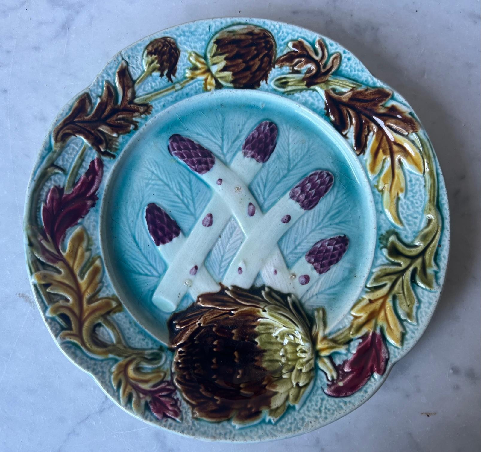 Vibrantly colored French majolica asparagus and artichoke plate made in the Orchies factory in the late 1800's. The plate has a scalloped rim with artichoke flowers and fall colored leaves, the largest flower is a depressed sauce well. The center of