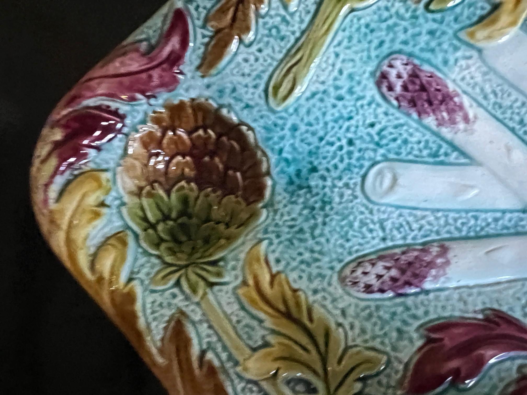 Vibrantly colored French majolica asparagus and artichoke platter made in the Orchies factory in the late 1800's. The tray has a scalloped rim , a turquoise background with artichoke flowers and fall colored leaves. The depressed sauce wells on each