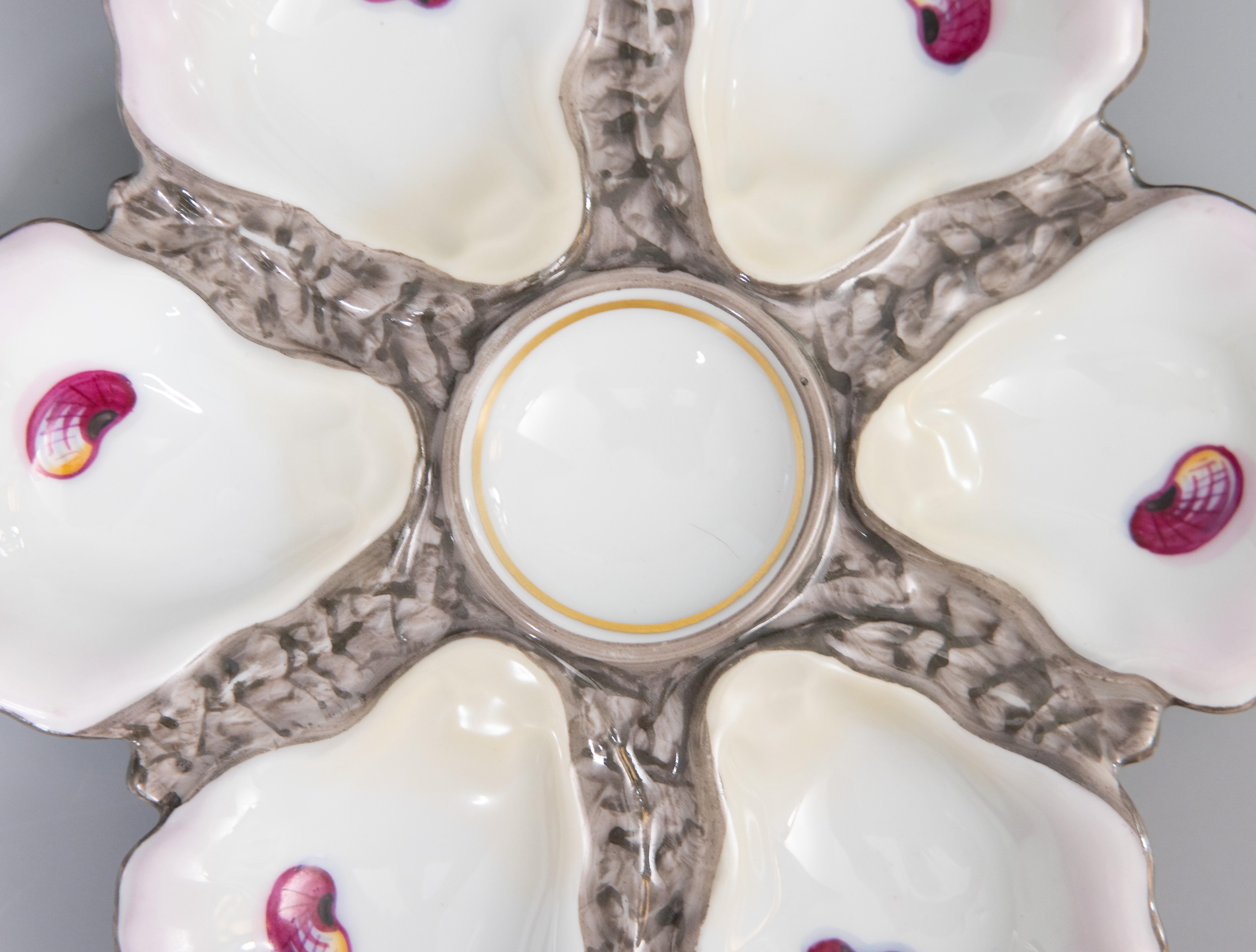 A gorgeous antique 19th-century French porcelain oyster plate. This fine quality oyster plate has six wells and a lovely soft pink tint on the edges. It displays beautifully and would also be perfect for serving.

DIMENSIONS
9.25