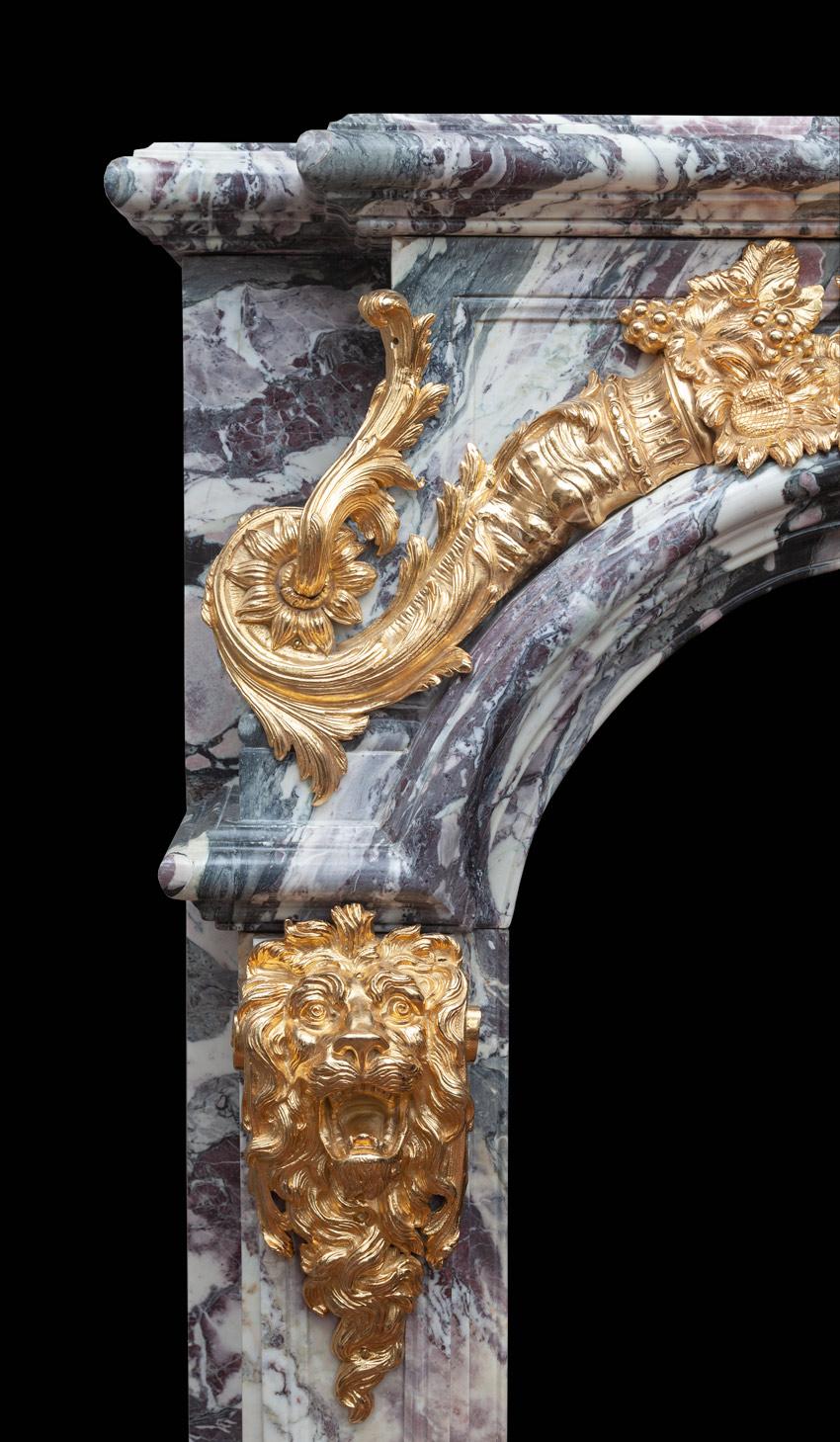 Antigua repisa francesa de mármol y bronce dorado de excepcional calidad y gran tamaño. Según un diseño de François Antoine Vassé (1681-1736) para el Salón de Hércules del Palacio de Versalles, Francia. 

Fabricado con el mármol Breccia Violleta más