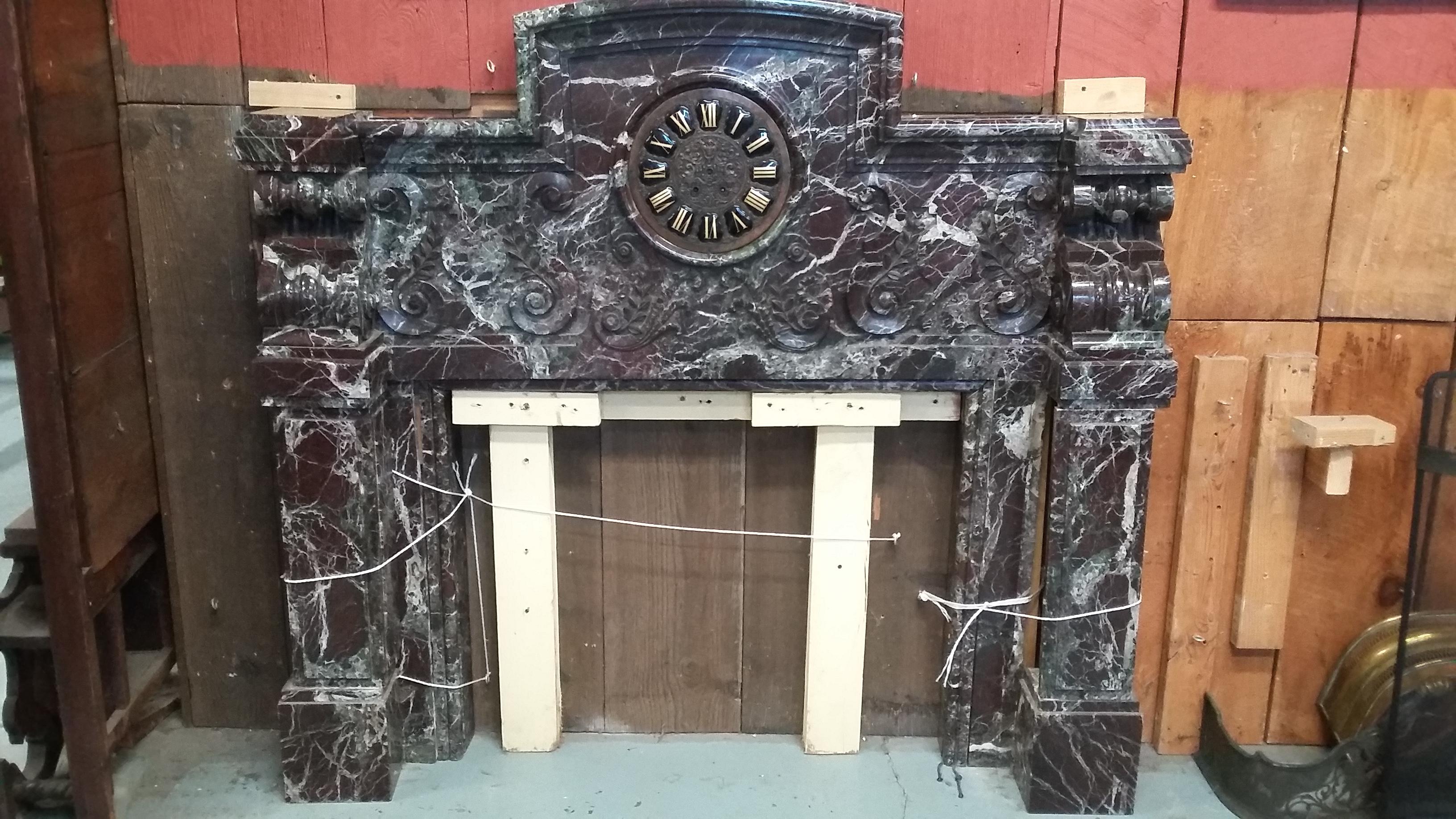 Very unique late 19th century French marble mantel. Wonderful deep rouge color marble with an unusual clock in the center. Straight lines with corbel design atop each side leg. Purchased from an antique dealer in France. Opening measures 37