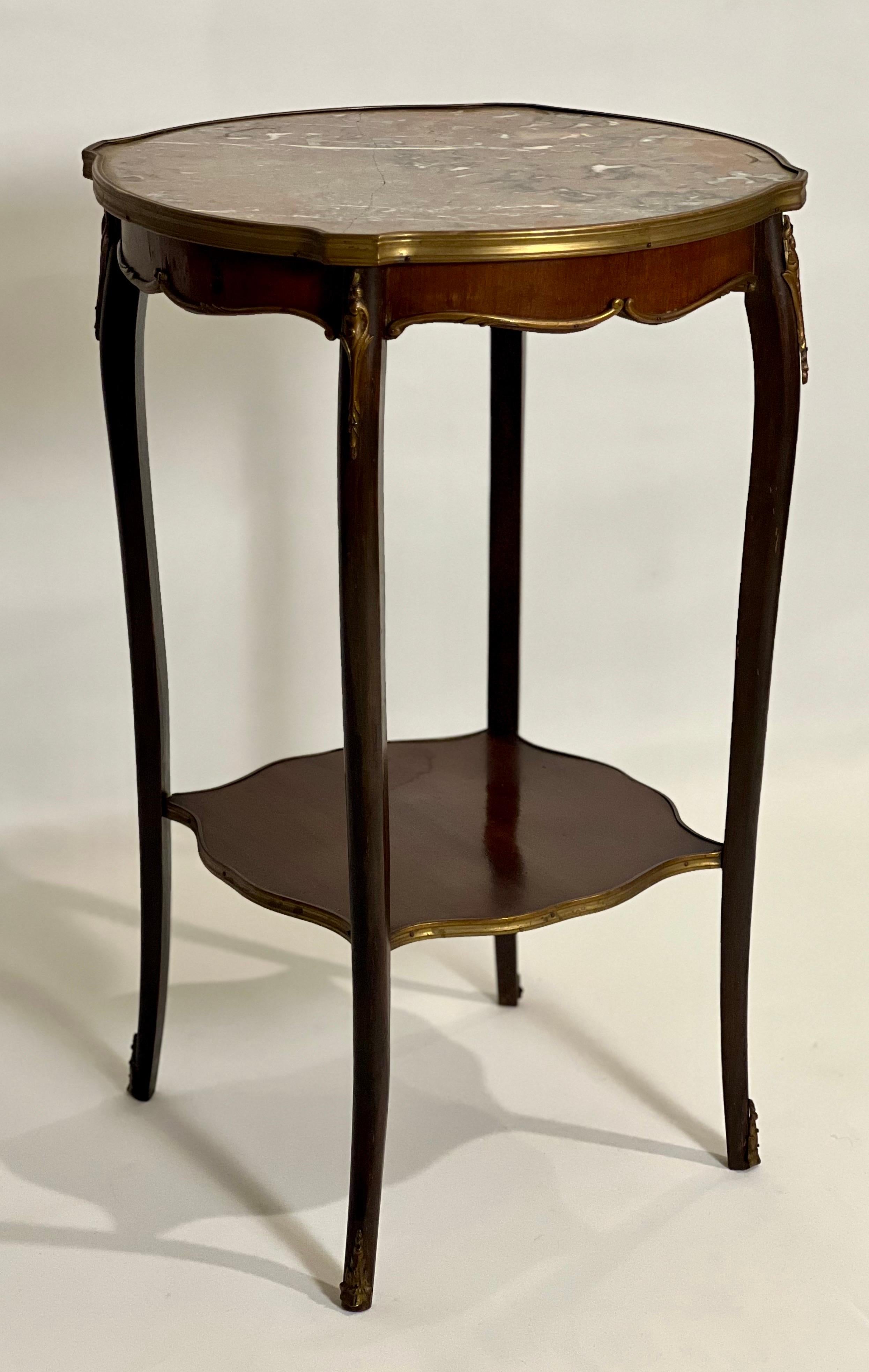 Antique French Louis XV style marble top bronze-mounted side table, c. 1890-1900.

A well-appointed French table with fine bronze embellishments, a fitted griotte marble top, lithe cabriole legs and lower tier. It boasts all the hallmarks of