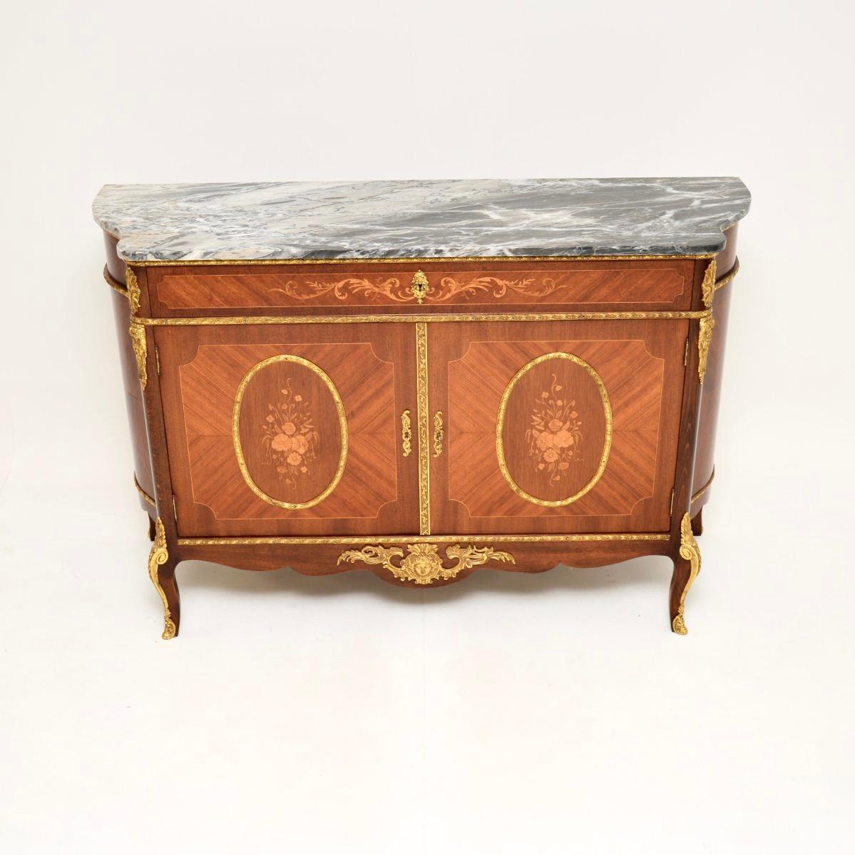A stunning antique French marble top cabinet, dating from around the 1930’s.

It is extremely well made with lots of fine features. The carcass is a mixture of woods, with gorgeous floral inlays. There are high quality ormolu mounts throughout, and