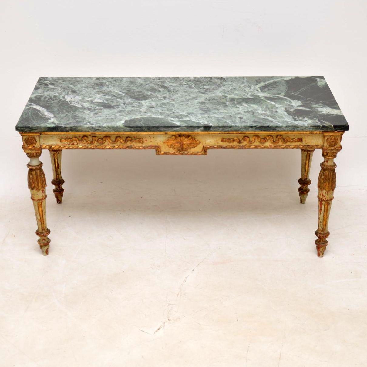 This antique French marble-top coffee table has the original painted finish and is naturally distressed with loads of character. You can see the original reddish under layer showing in places beneath the paintwork which is embellished with gilt work