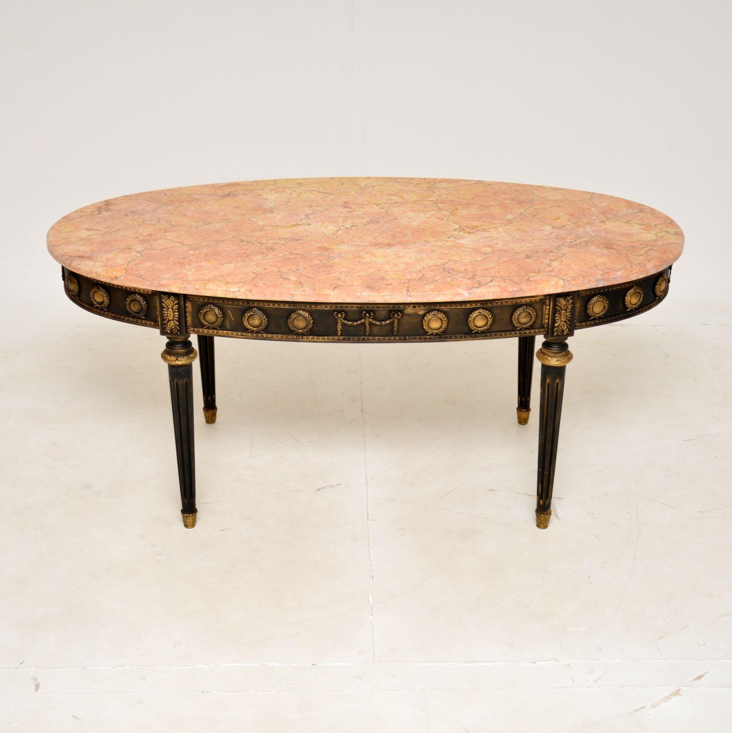 A lovely antique French marble top coffee table, dating from around the 1950s.

This is very well made and has a striking look. The frame has a distressed black finish, and is offset nicely by the gilt metal ormolu mounts and pink marble