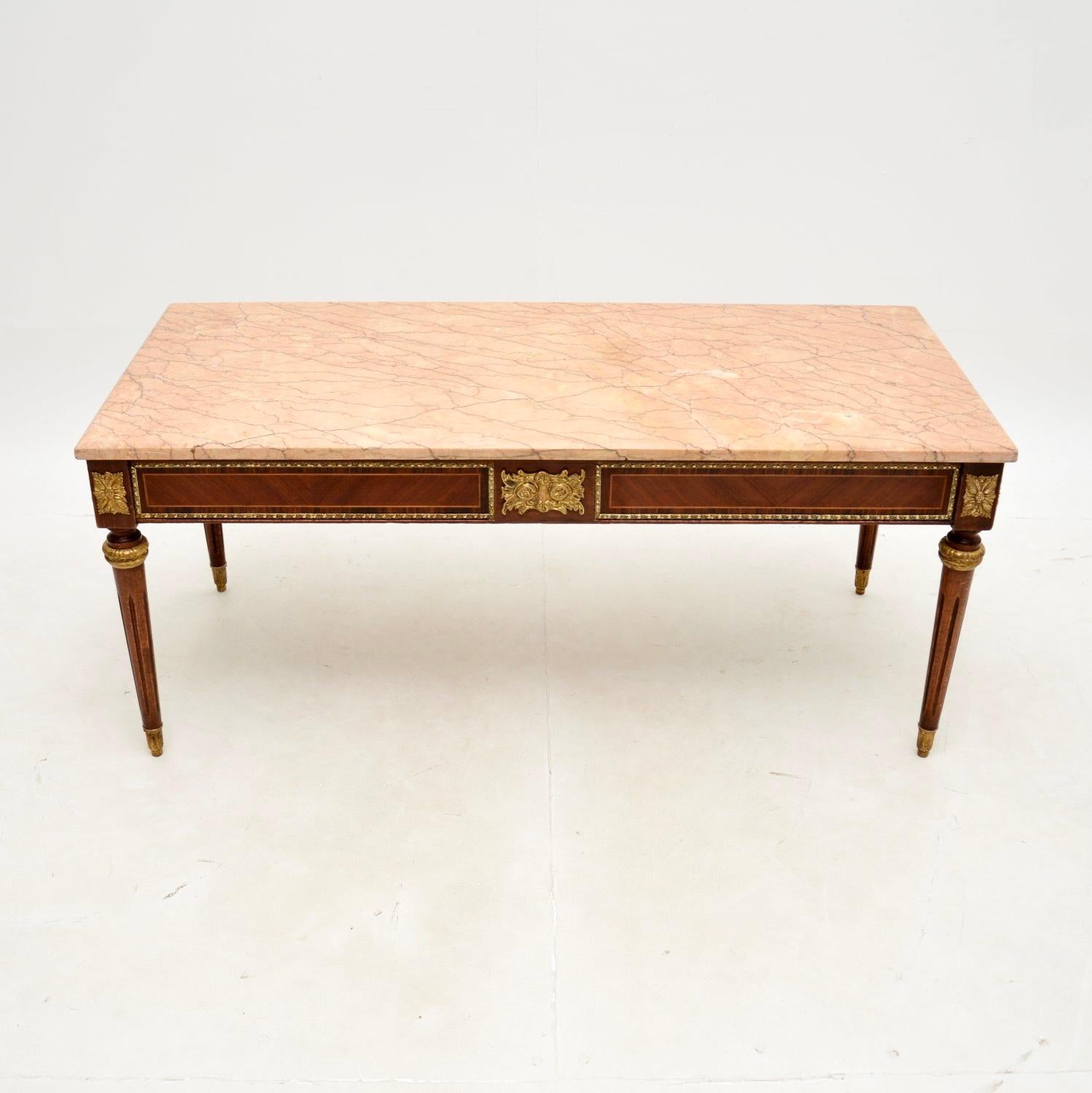 A beautiful and extremely well made antique French marble top coffee table, dating from around the 1930’s.

This is of superb quality, the frame is made from various woods, predominantly walnut. There are high quality ormolu mounts throughout, and a