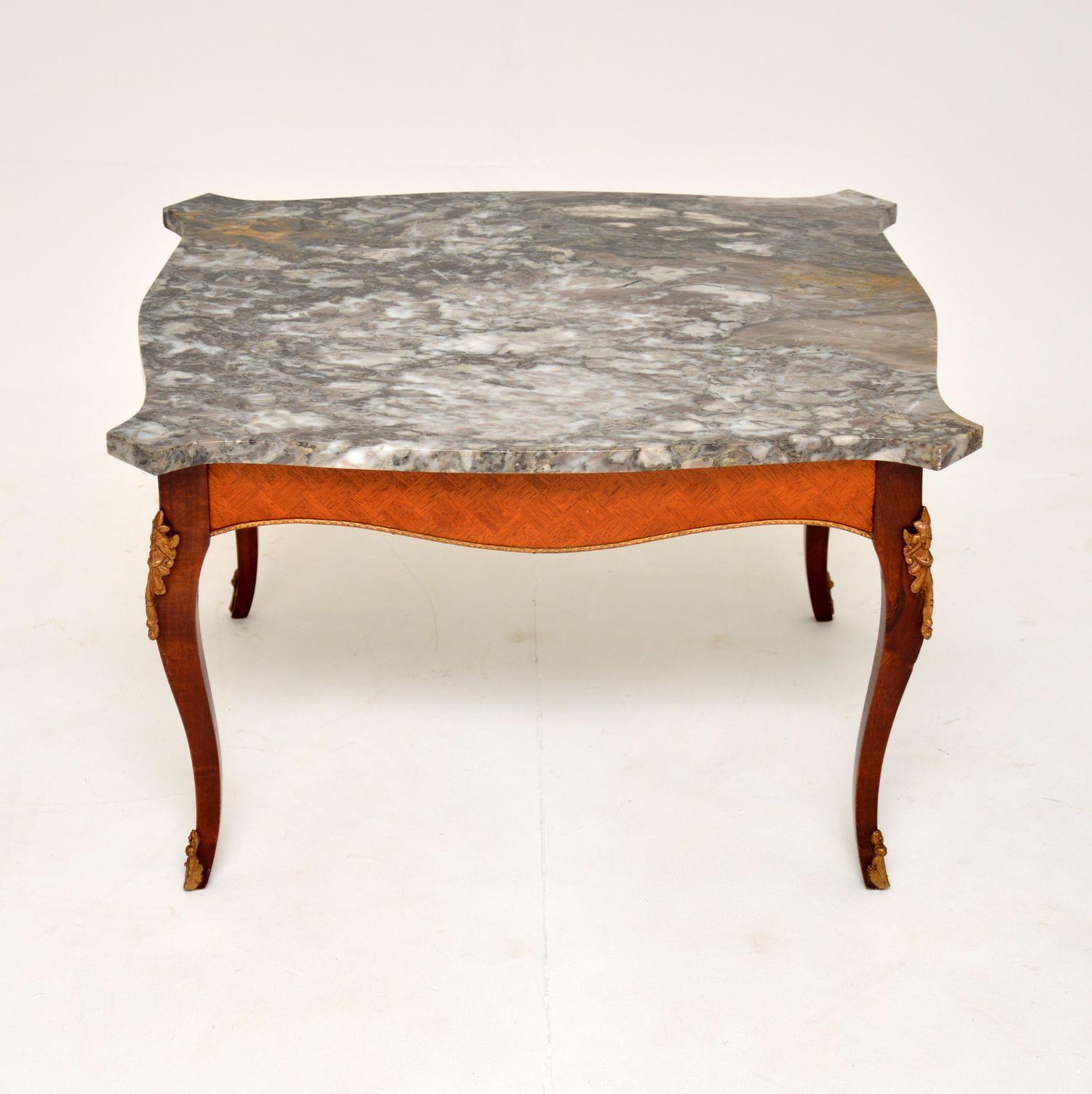 A beautiful antique marble top coffee table. This was made in France, it dates from around the 1920-30’s.

It is of excellent quality, the frame has beautiful veneers on the sides and high quality gilt metal mounts. the marble top has stunning