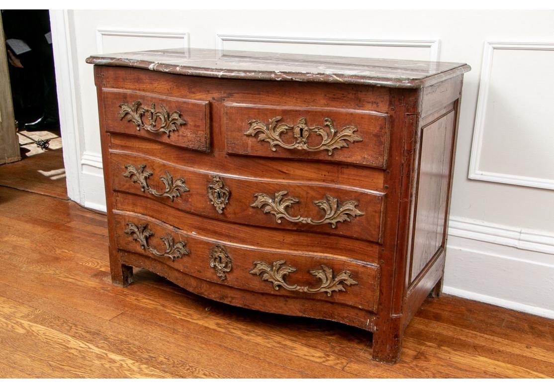A very fine smaller scale French chest suitable for use between chairs or as a side table or nightstand. A shaped case with conforming red marble top. Two short over two long drawers with large-scale fine brass baroque style pulls and escutcheons.