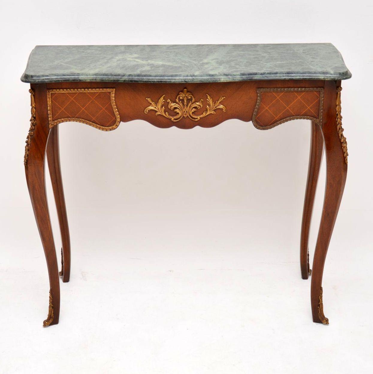 Antique French marble-top console side table in mahogany and king wood with some fine satinwood diamond shaped inlays around the top edge. This table has gilt bronze mounts and feet which have mellowed with age. It has French cabriole legs and the