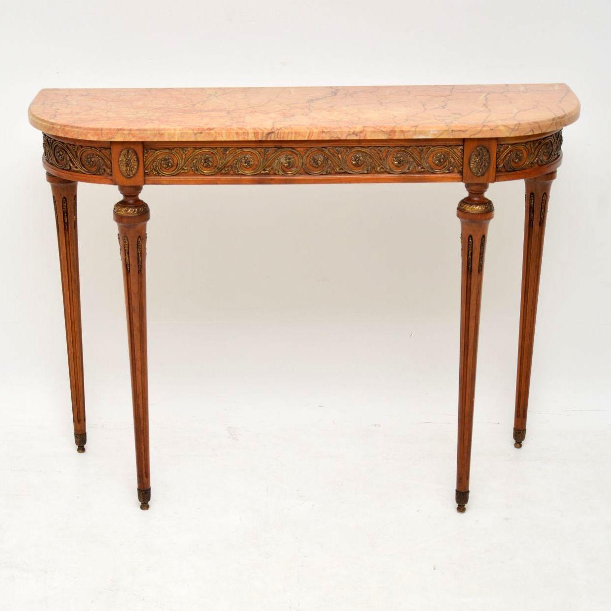 Antique French style marble top walnut console side table dating from around the 1930s period and in very good condition. It has gilt bronze mounts all around the top front edge and down all the turned fluted legs, which have gilt metal feet. The