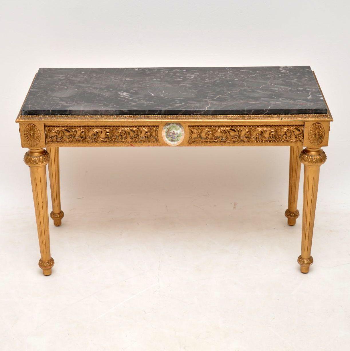 Antique French style marble top gilt coffee table with painted porcelain plaques, in fine condition and dating to circa 1950s period. The marble top has some lovely patterns & colours. It just lifts off from the table.

Measures: Width 32 inches,