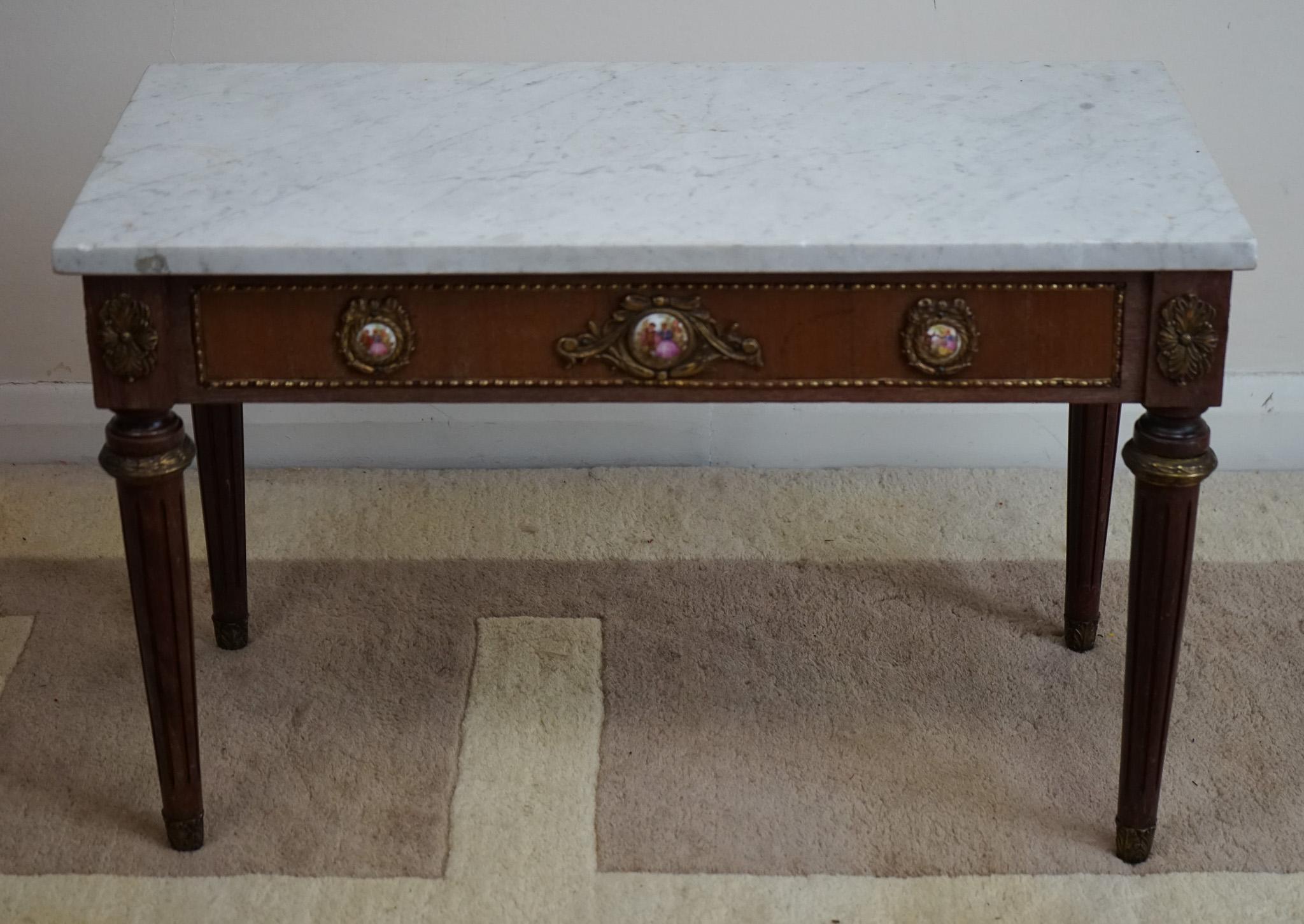 Antique French marble top  coffee table in good condition dating to around the 1930’s period. The marble top is original & in good condition too ( some chips on the corner )There are painted plaques surrounded by gilt bronze mounts all around the